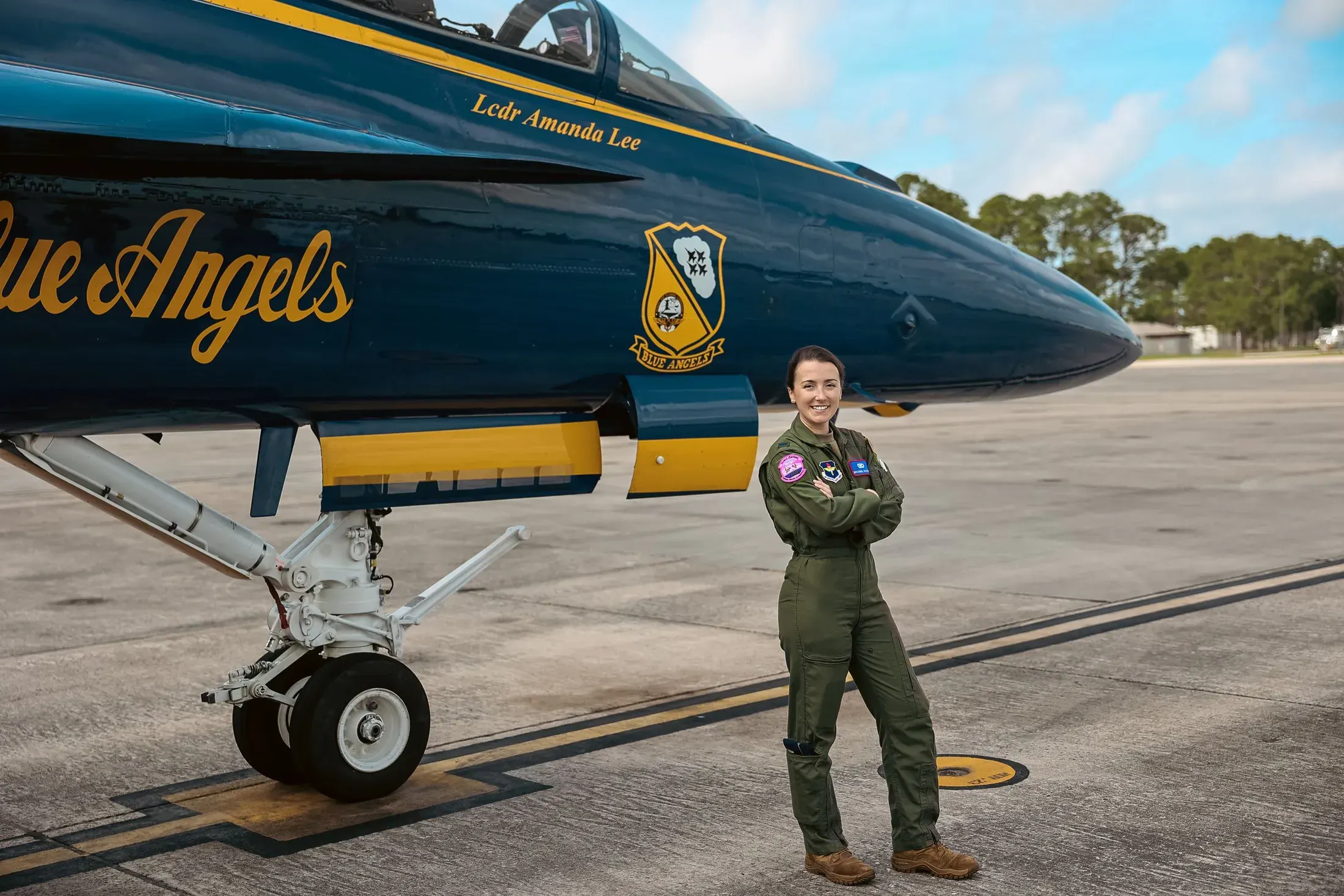 Aviator standing beside a Blue Angels jet