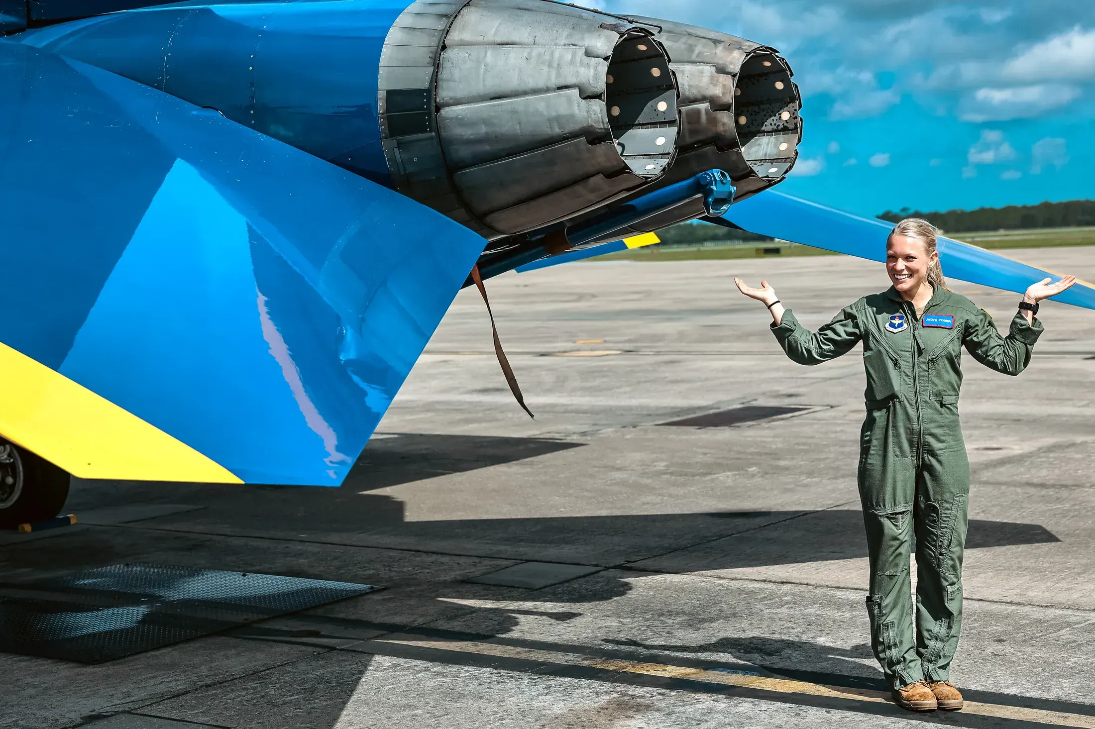 Aviator standing under the engines of a Blue Angels jet
