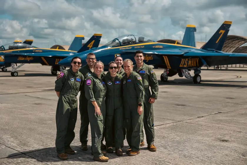 Aviators in flight suits in front of Blue Angels jets