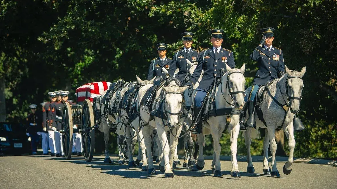 Horse drawn caisson with a flag draped casket during military honors