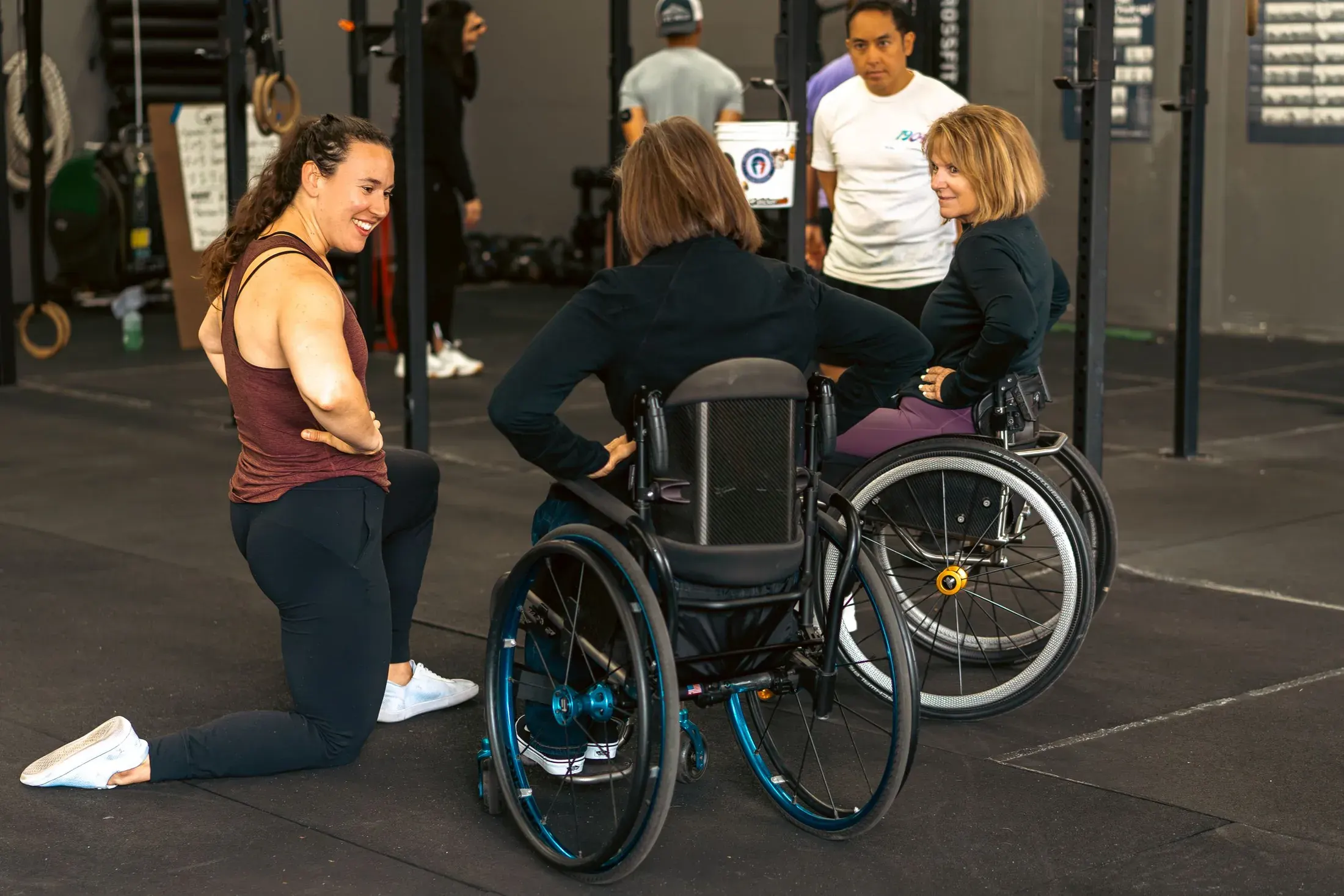 Coach kneeling to talk with an adaptive athlete