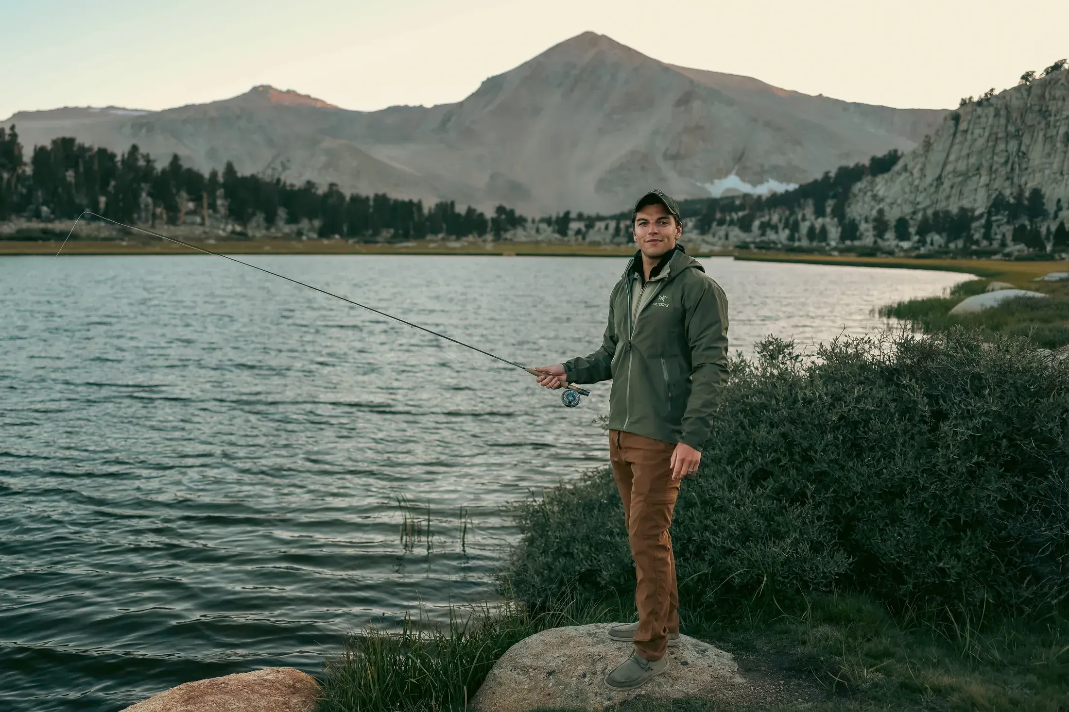 Fly fisherman on the shore of a mountain lake