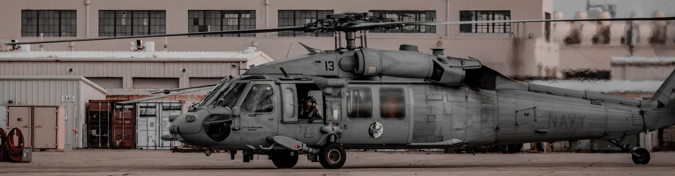 Navy helicopter parked outside a hangar