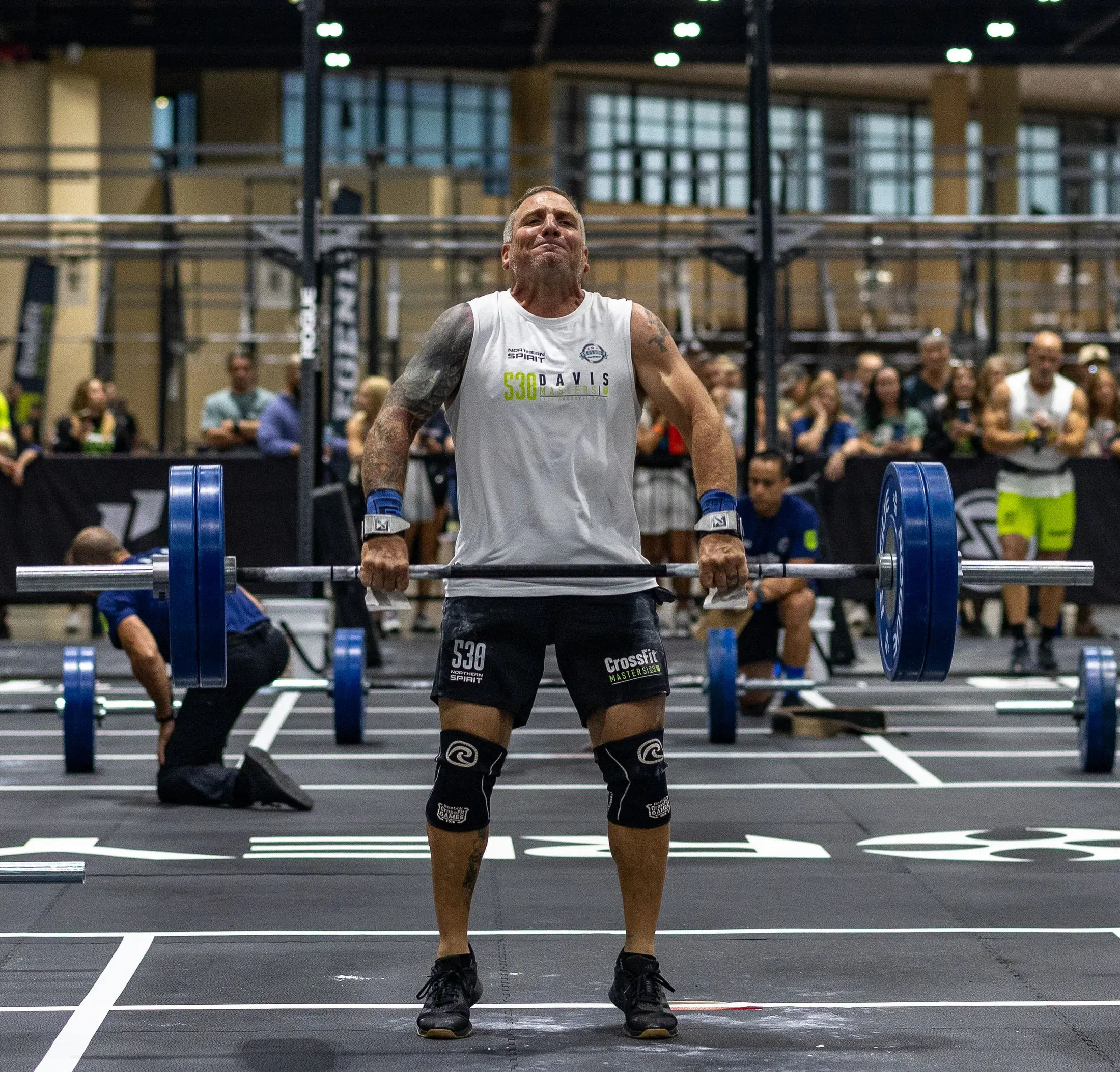 Competitor standing over a loaded barbell at a CrossFit competition