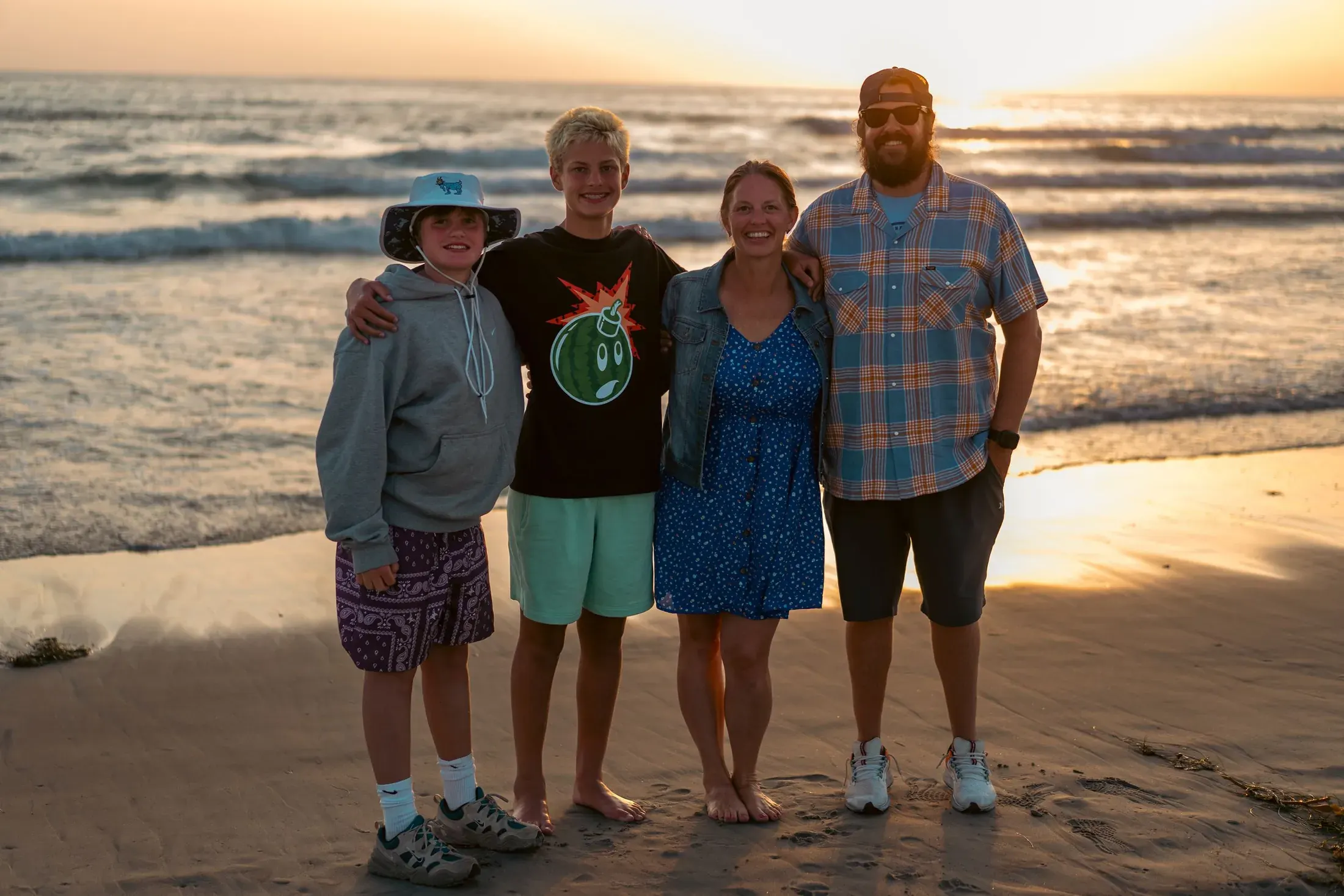 Family of four on the beach at sunset