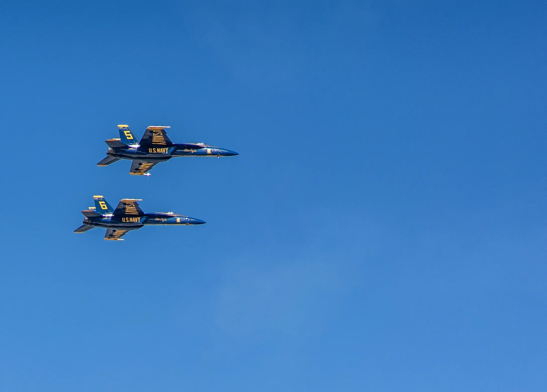Two Blue Angels jets in tight formation