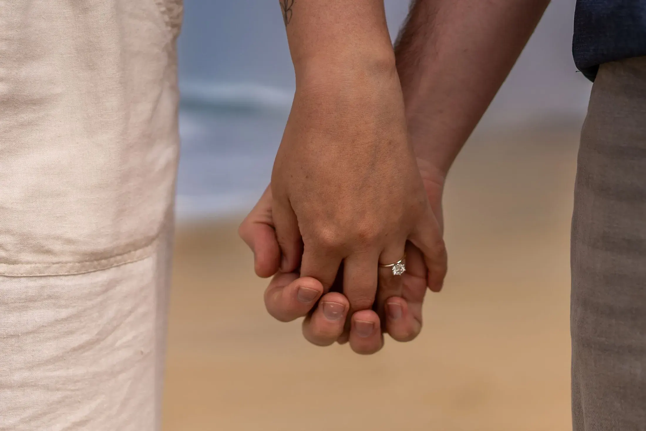 Close up of an engaged couple holding hands