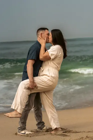 Couple kissing at the edge of the surf