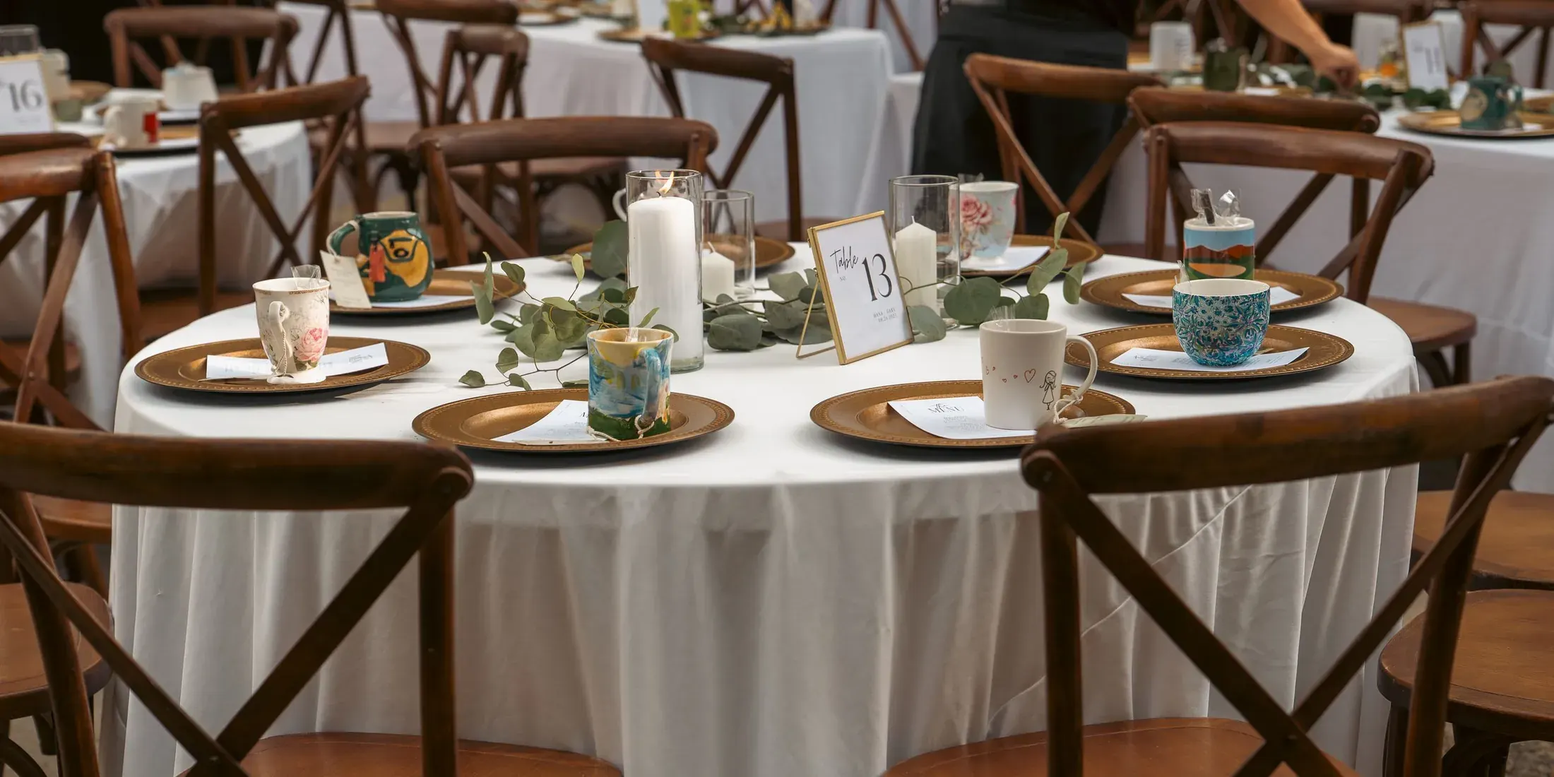Reception tables set with plates and greenery