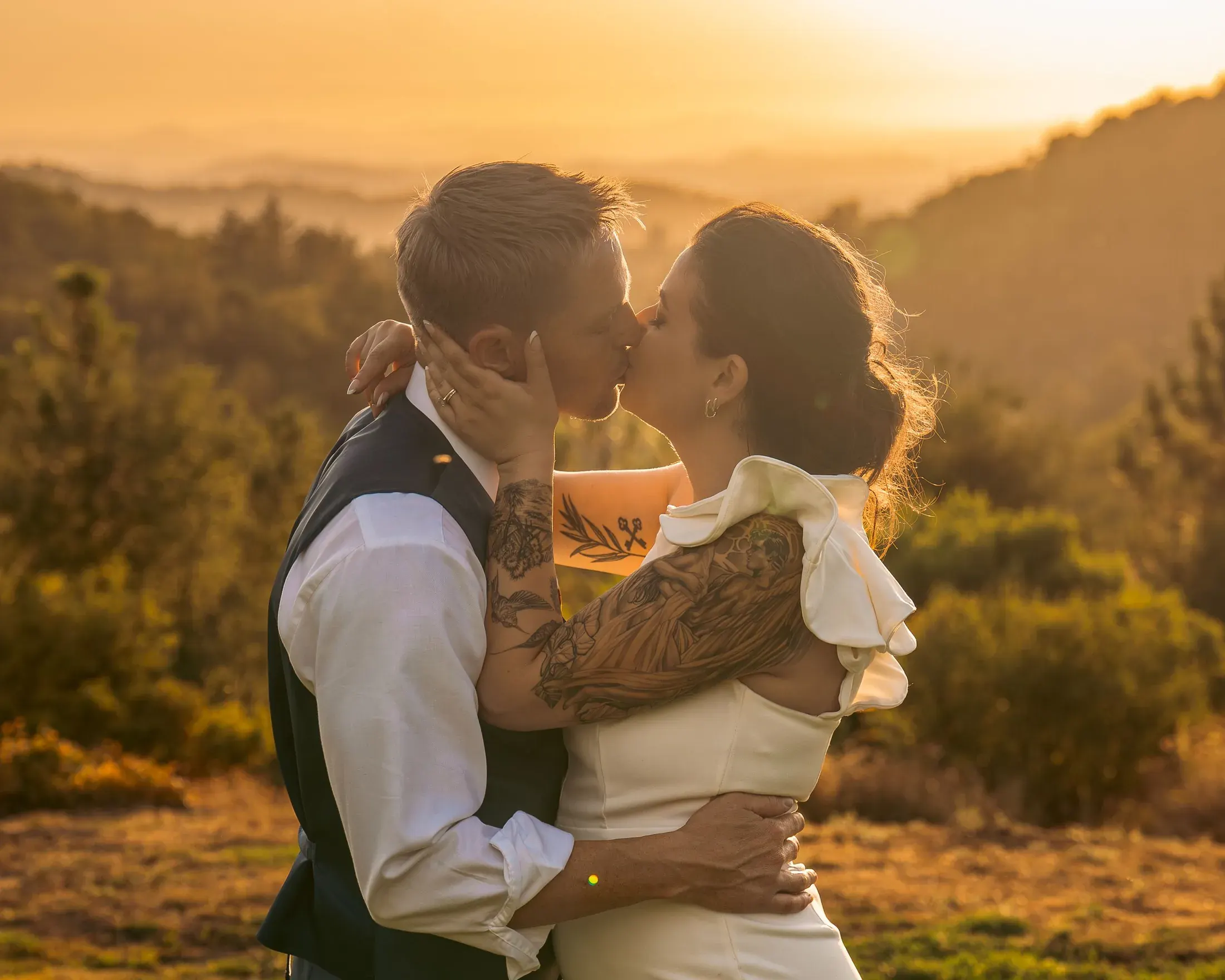 Couple kissing at golden hour in the hills