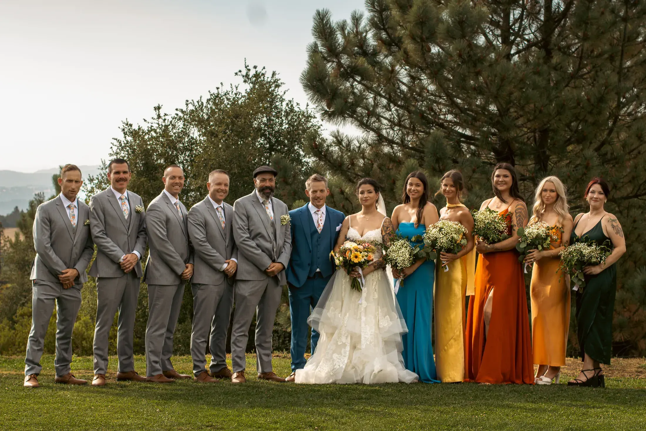 Full wedding party lined up on the lawn