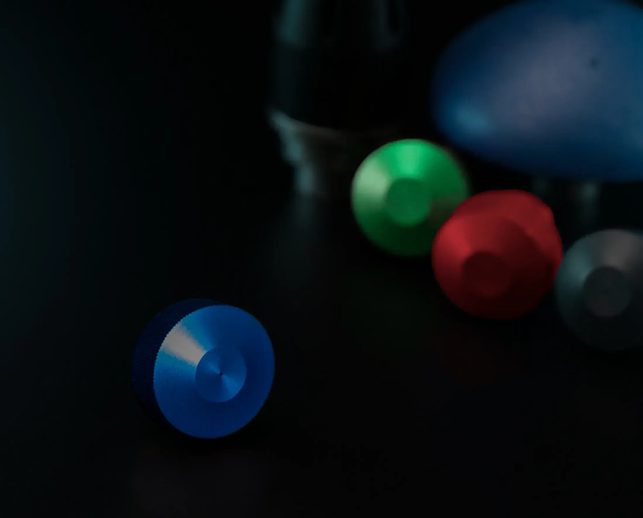Colorful machined aluminum parts on a black surface