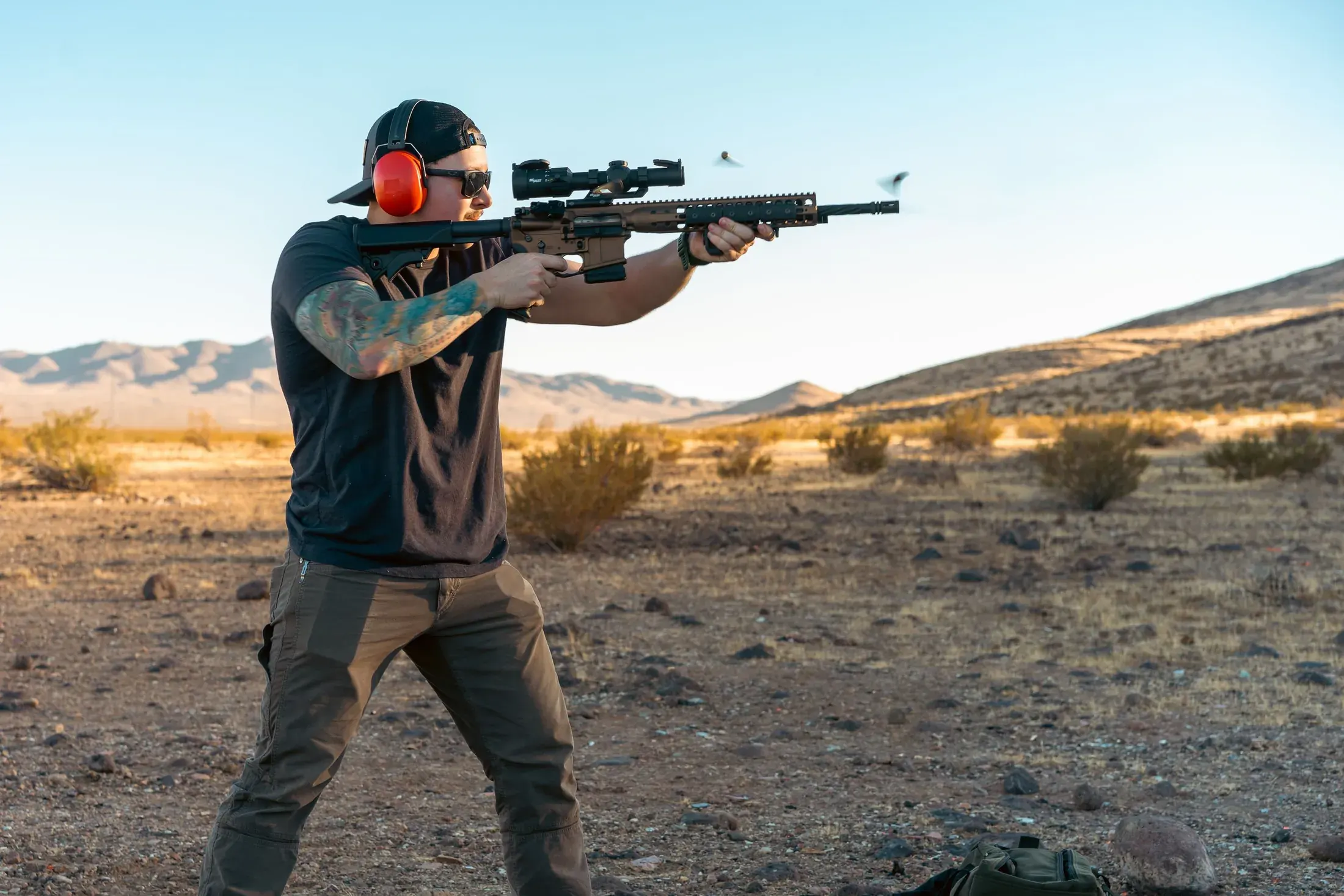 Shooter firing a rifle in the desert