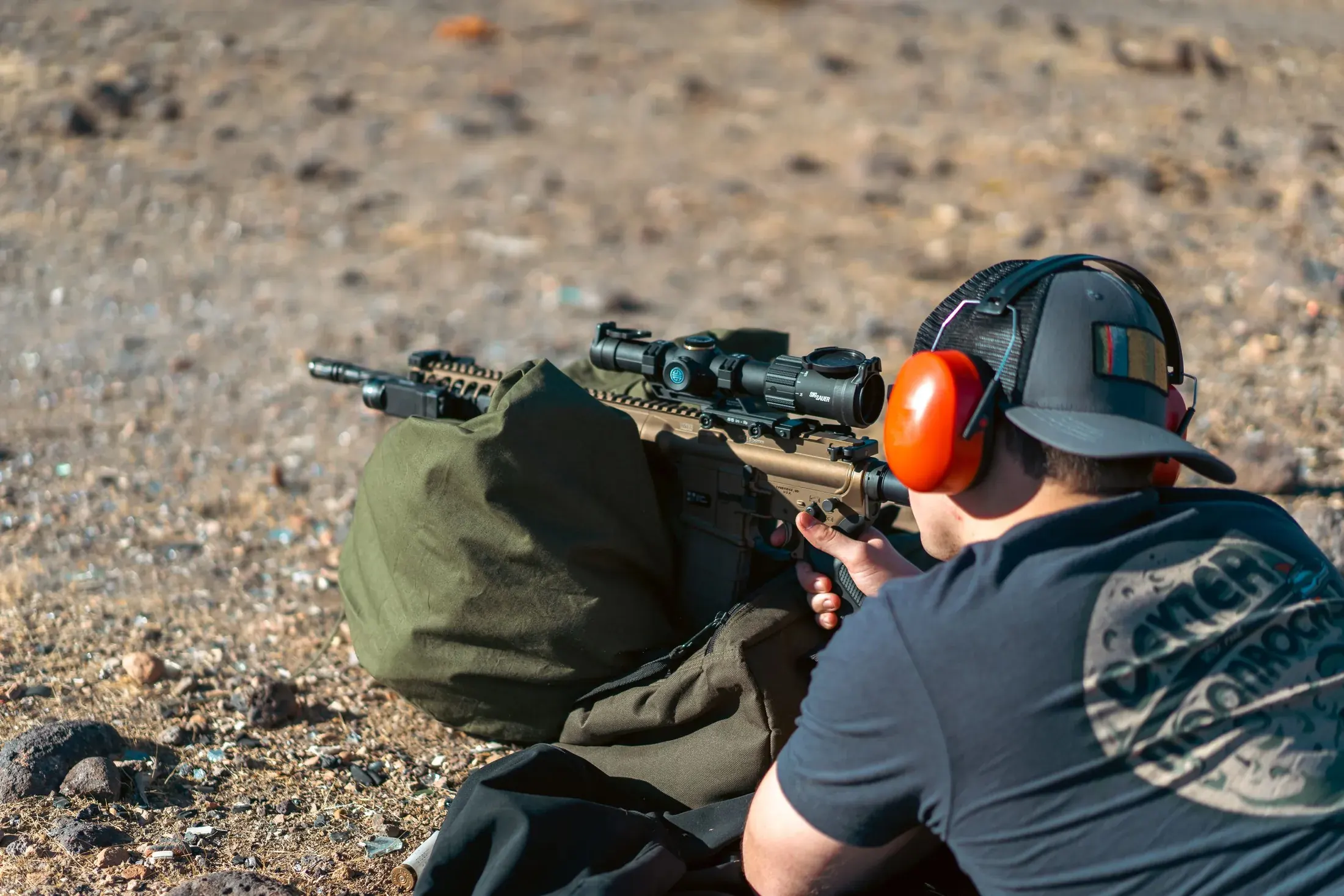 Shooter in ear protection aiming a rifle