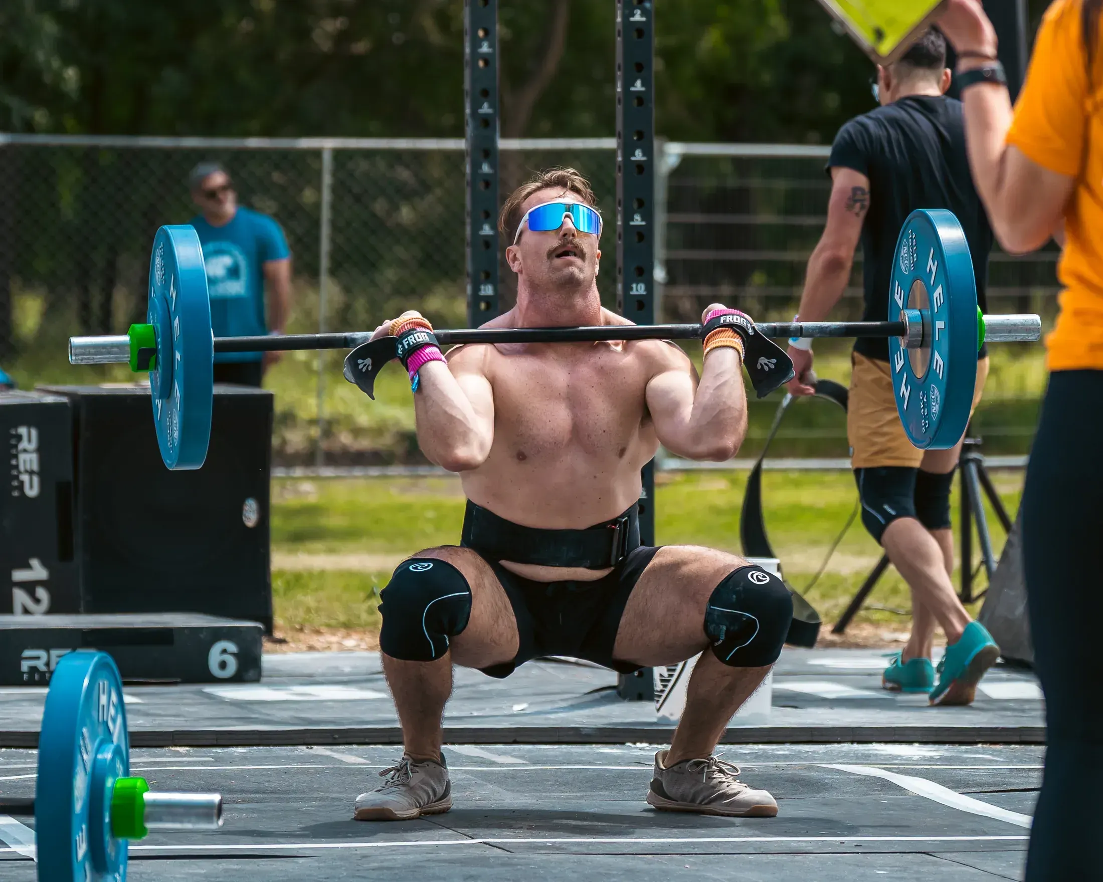 Athlete catching a heavy clean at an outdoor competition