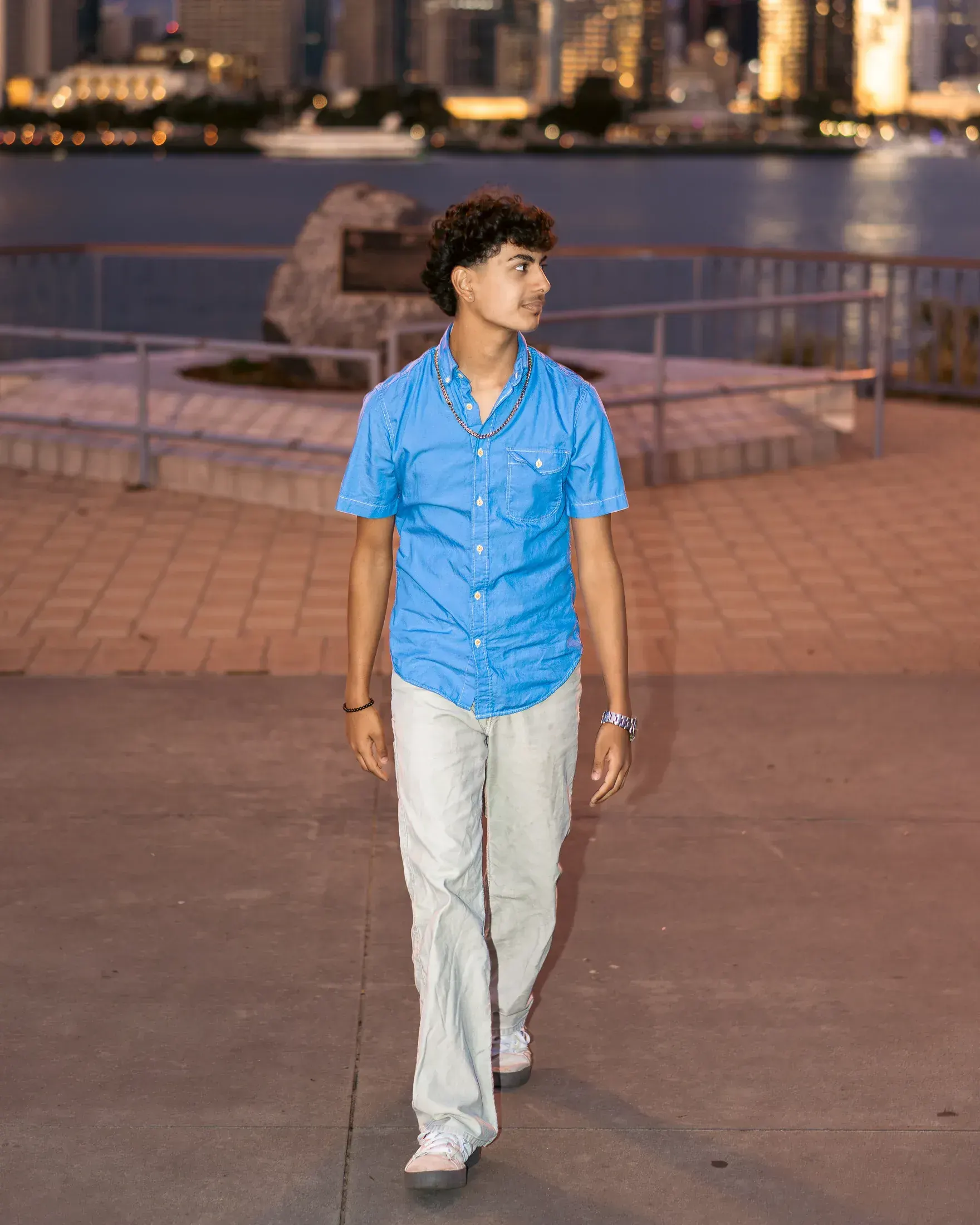 Young man in a blue shirt walking along the bay