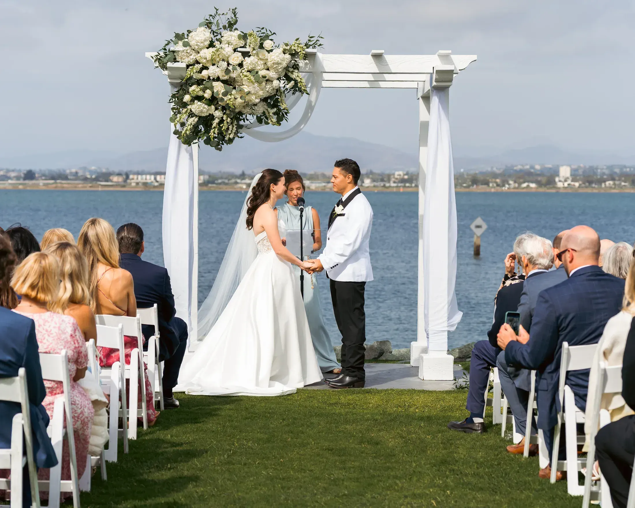 Bride and groom at a floral altar on the bay