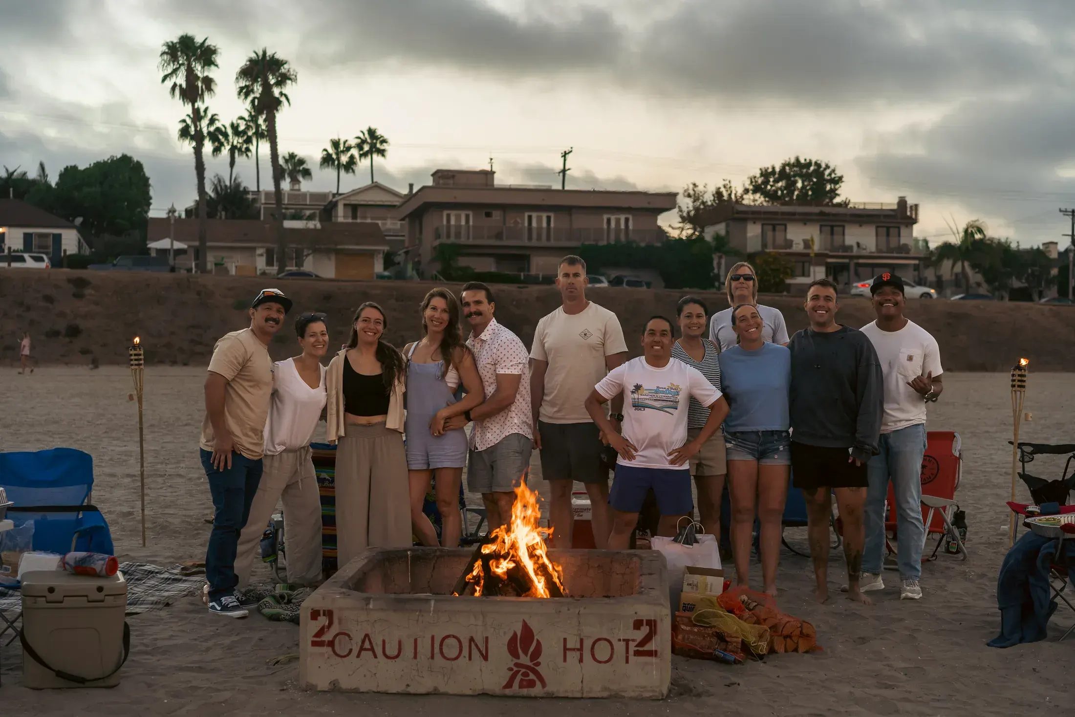 Extended family gathered around a beach bonfire
