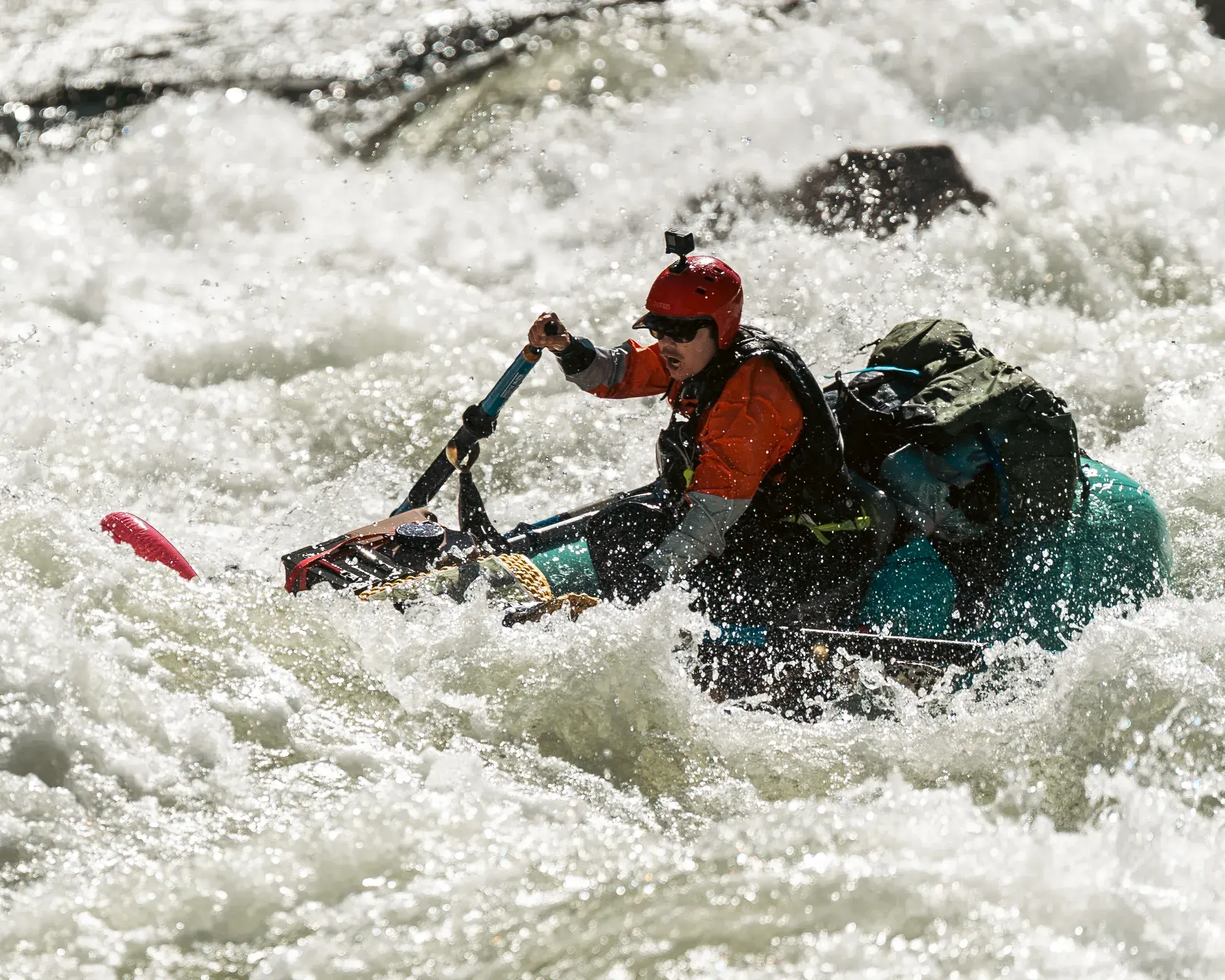 Rafter paddling hard through a wave train
