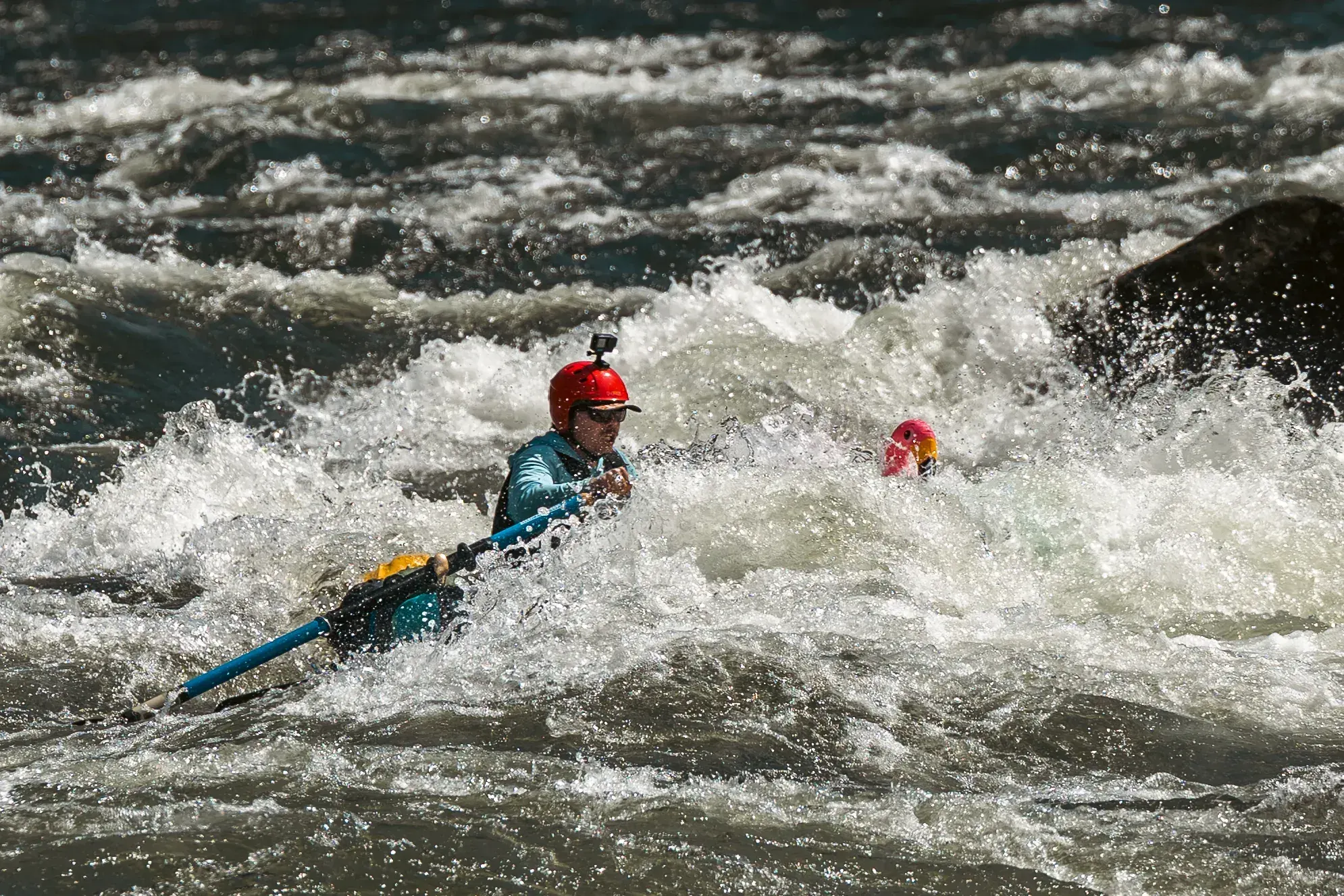 Two kayakers running a rapid