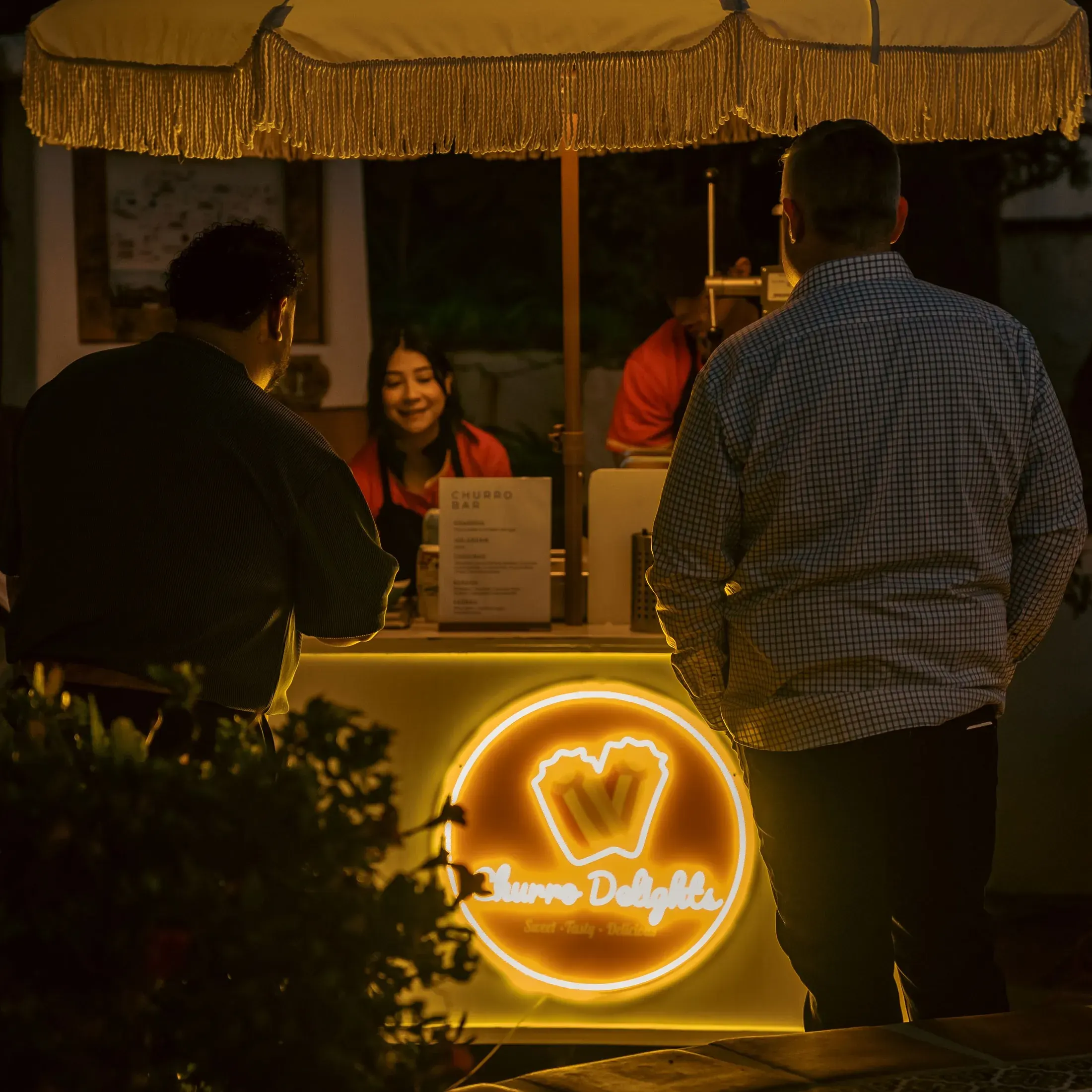 Guests at a neon lit dessert stand