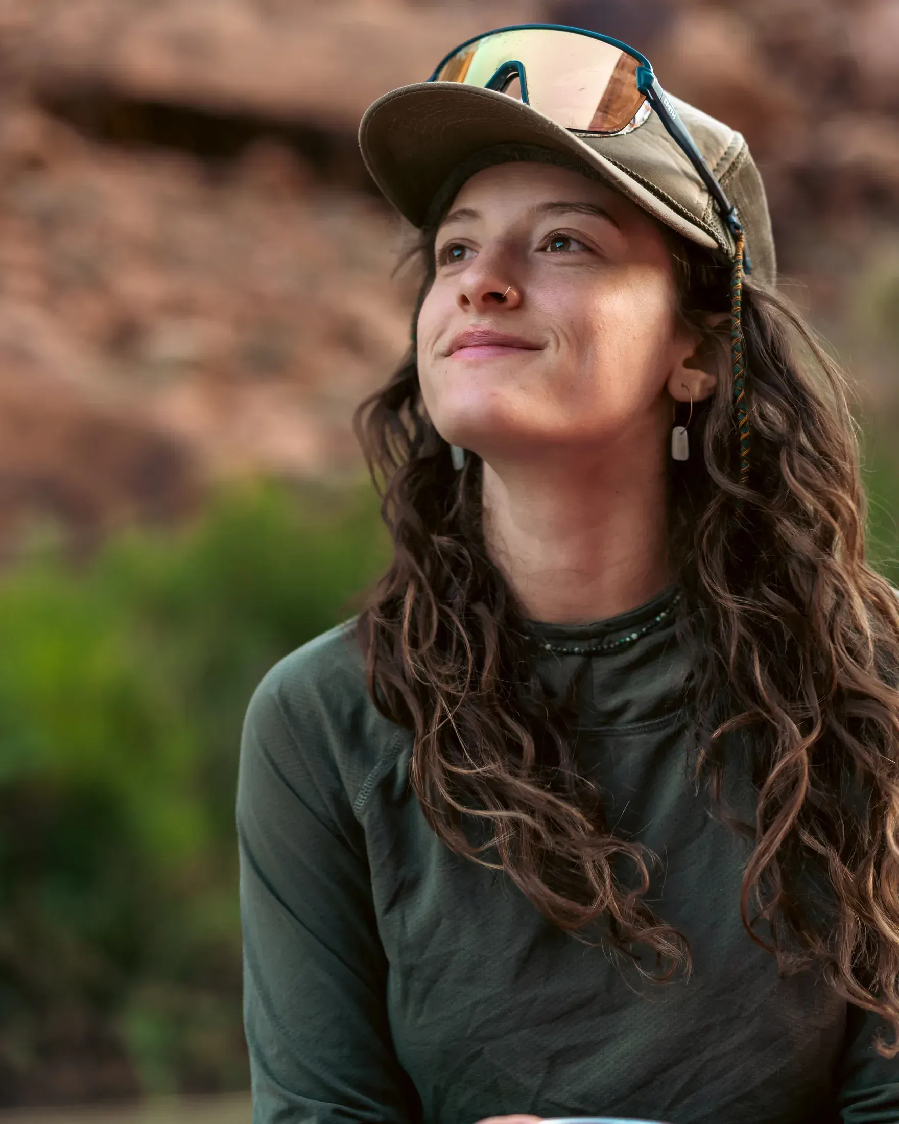 Woman in a trucker hat smiling in the canyon