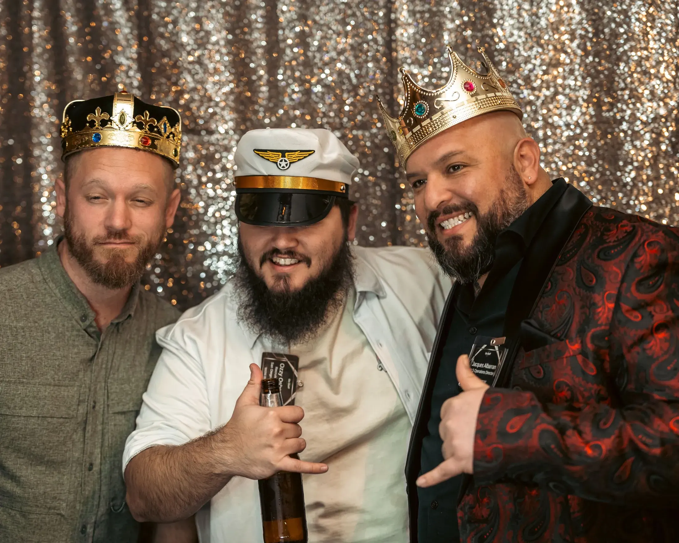 Three men in crowns and costumes at a party