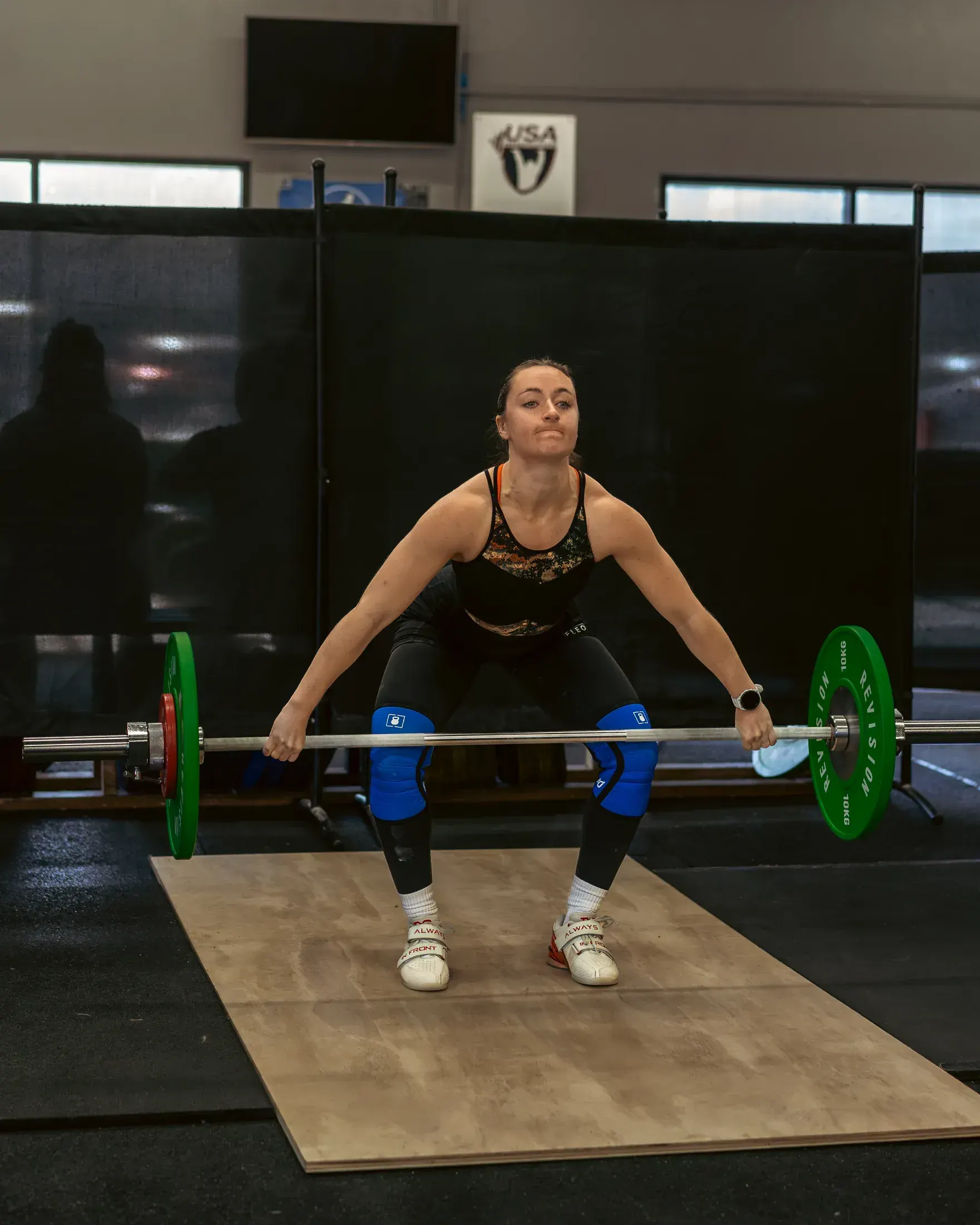 Weightlifter catching a snatch on the platform