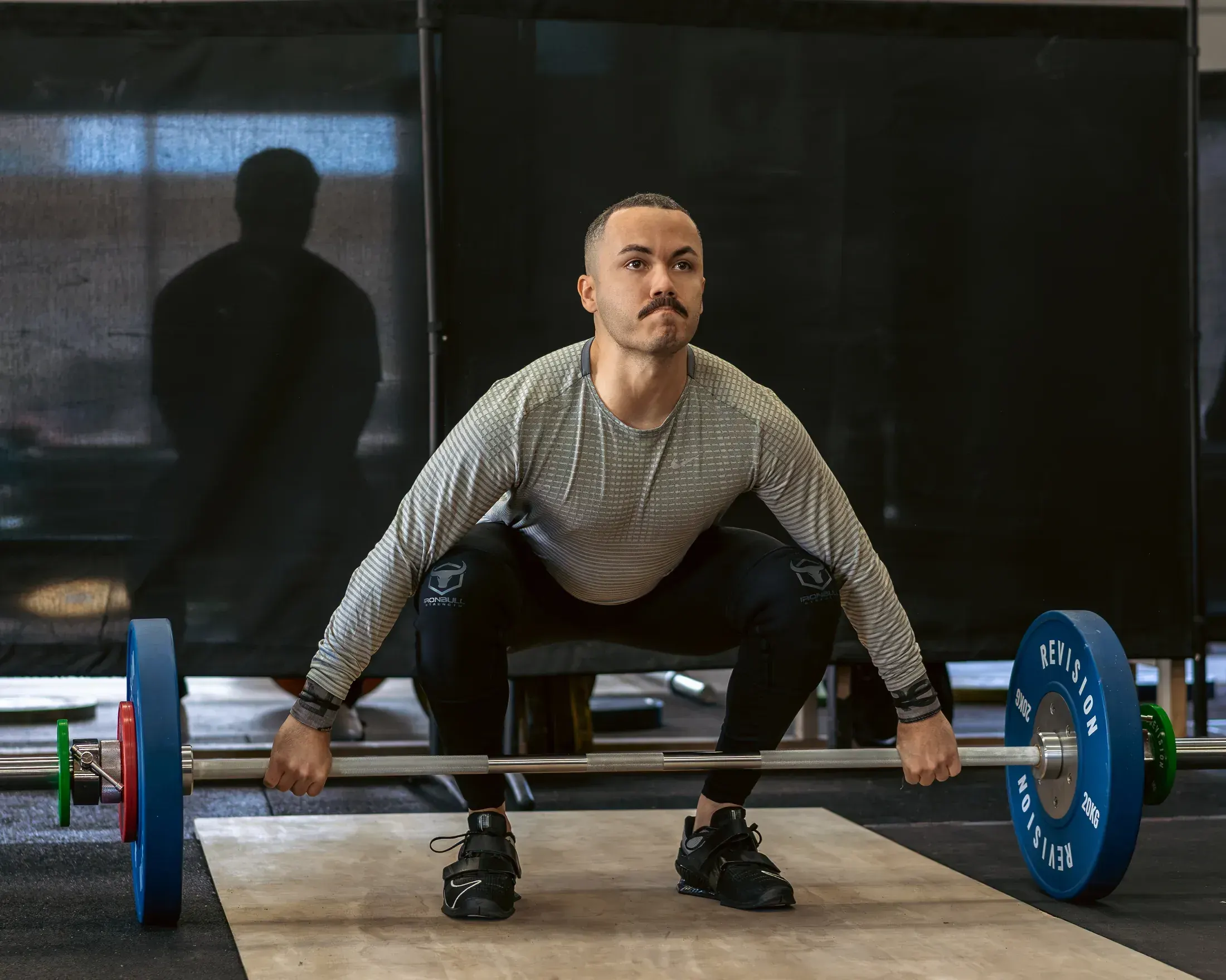 Weightlifter pulling a clean off the platform