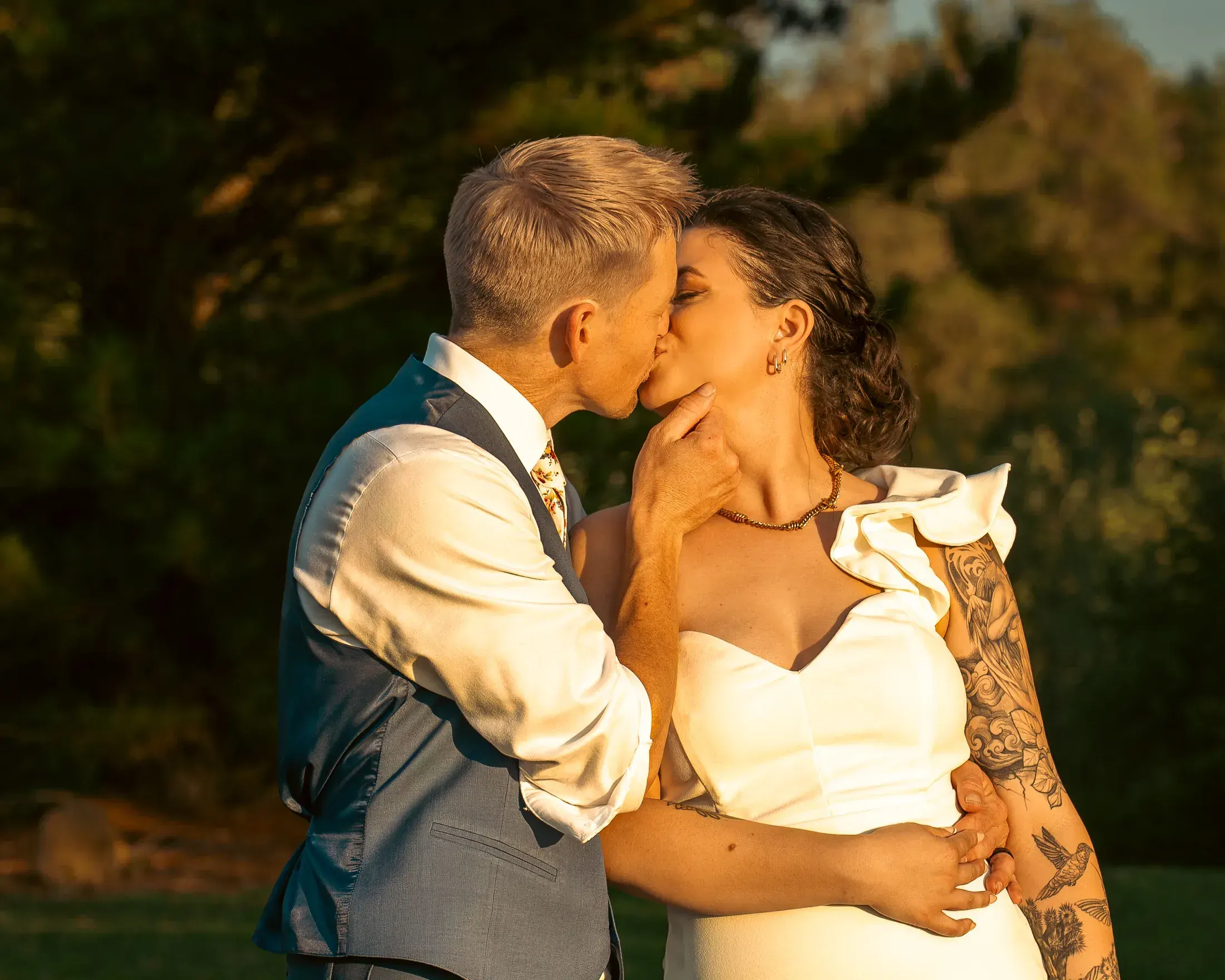Groom kissing the bride at golden hour