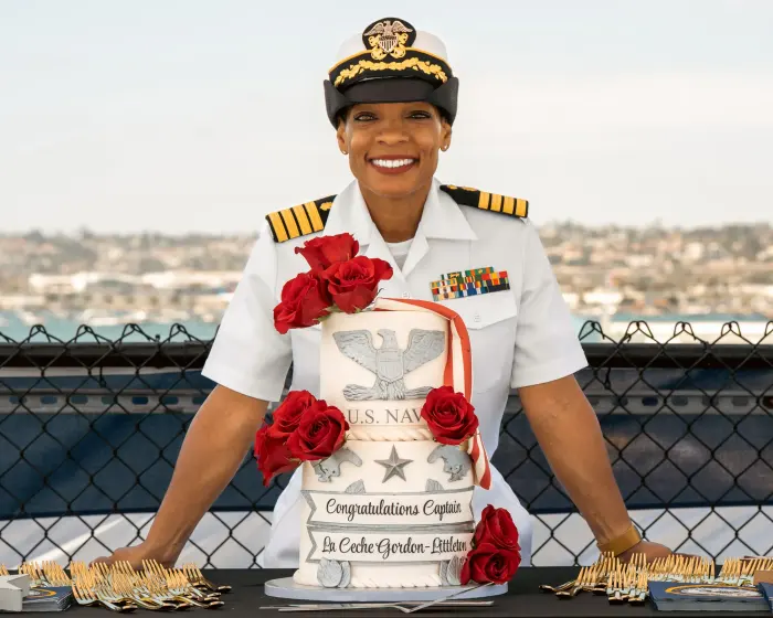 Newly promoted Navy Captain with a lei and her promotion cake