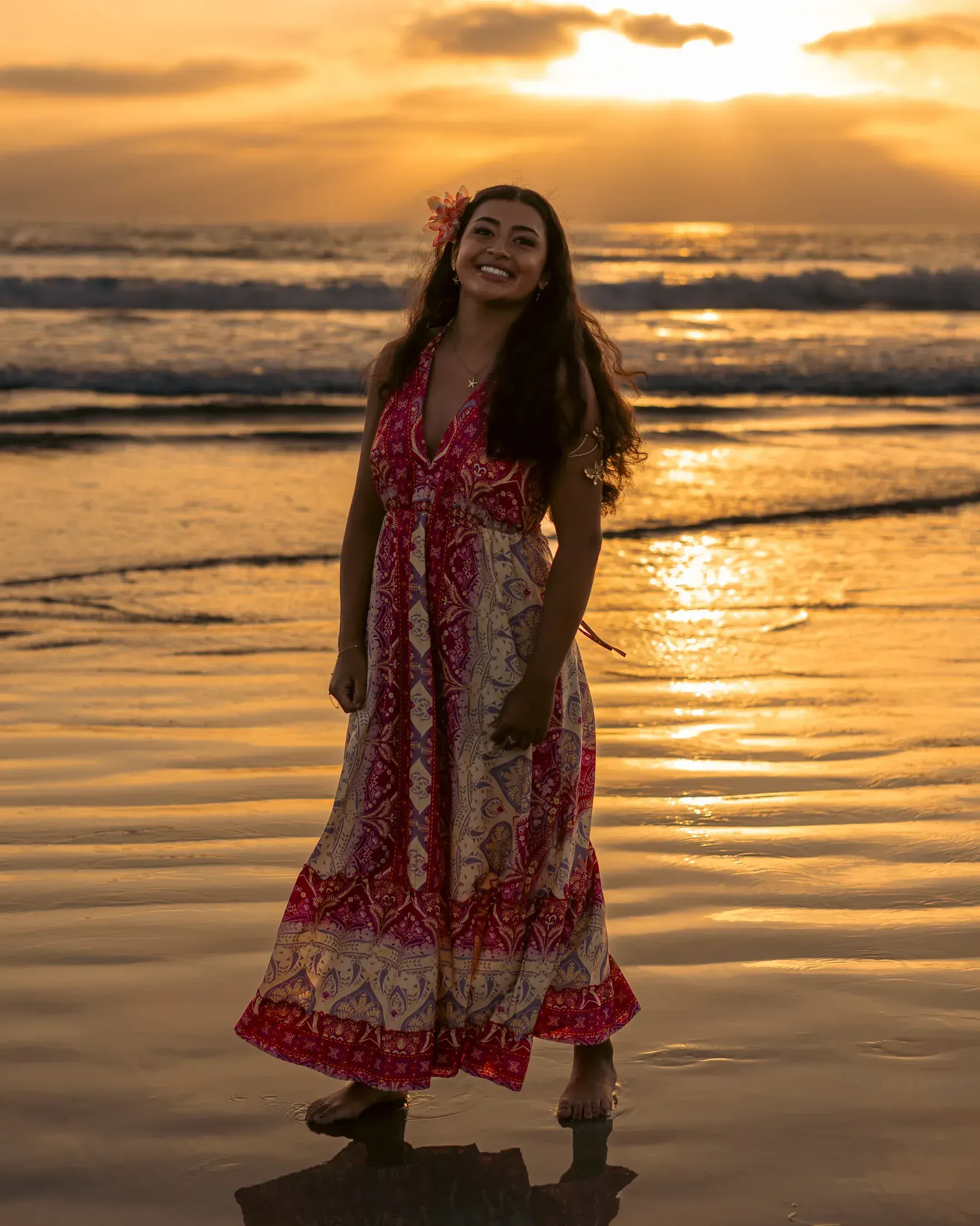 Woman in a red dress on the beach at sunset