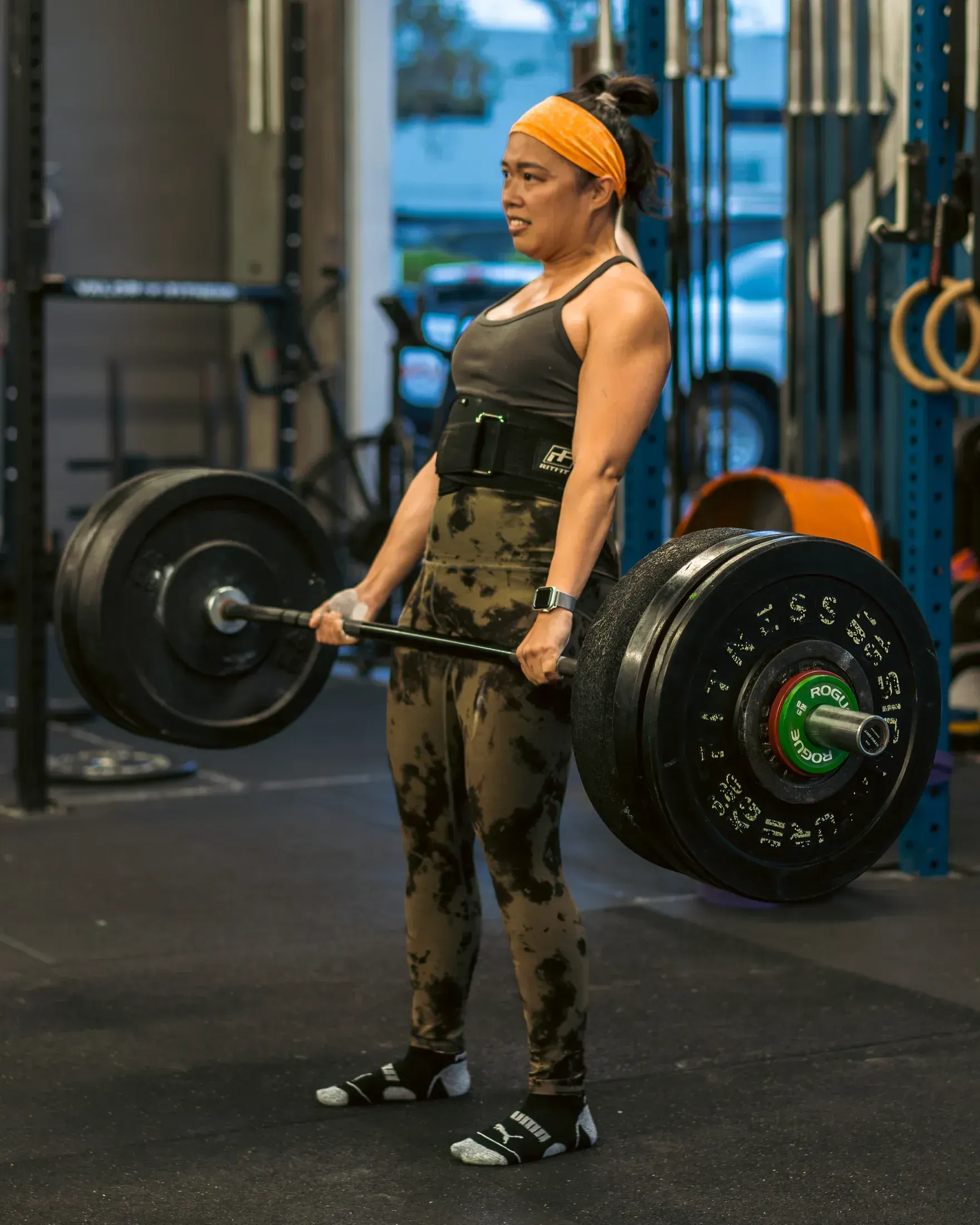 Athlete deadlifting a loaded barbell in the gym