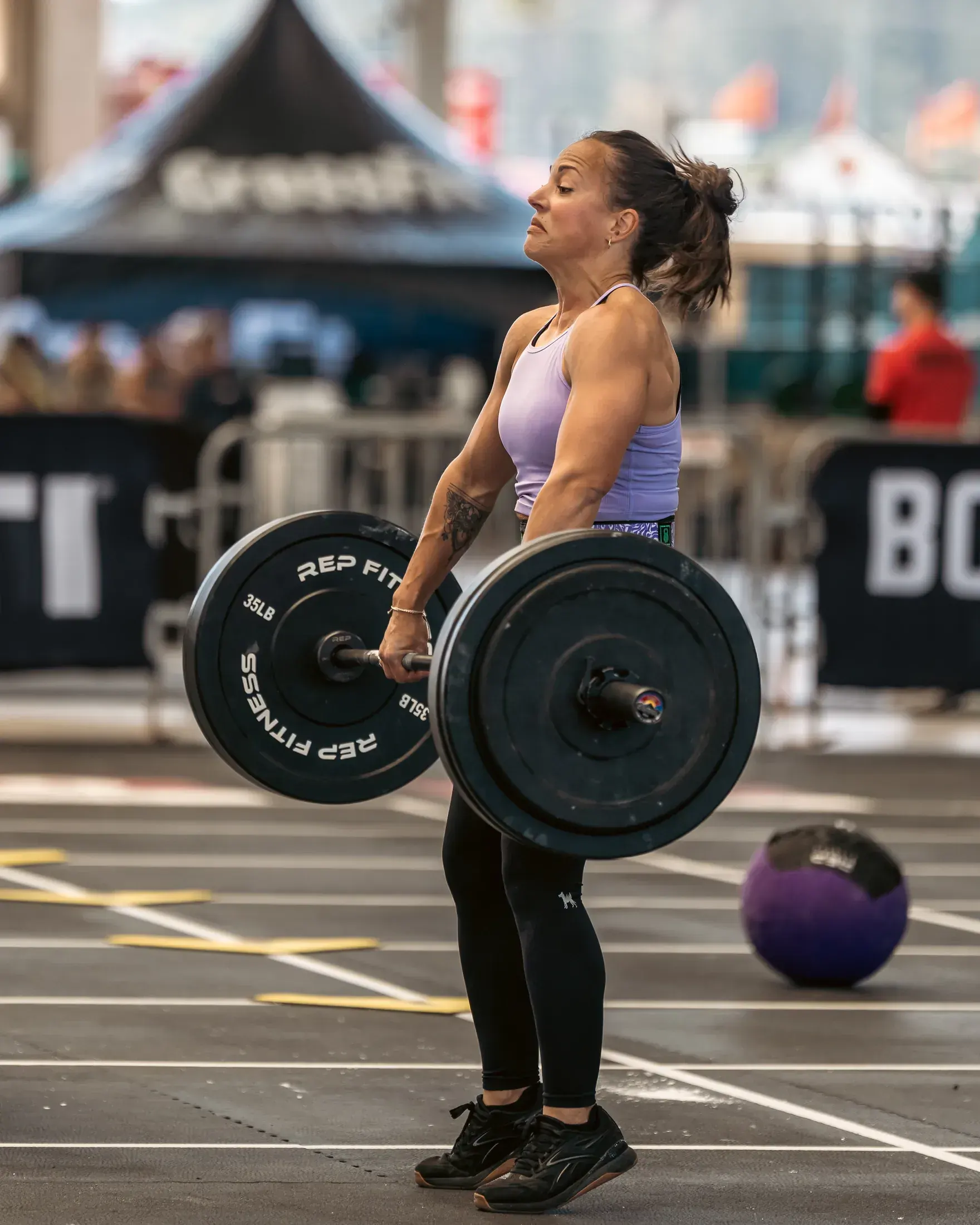 Athlete carrying a loaded barbell across the floor