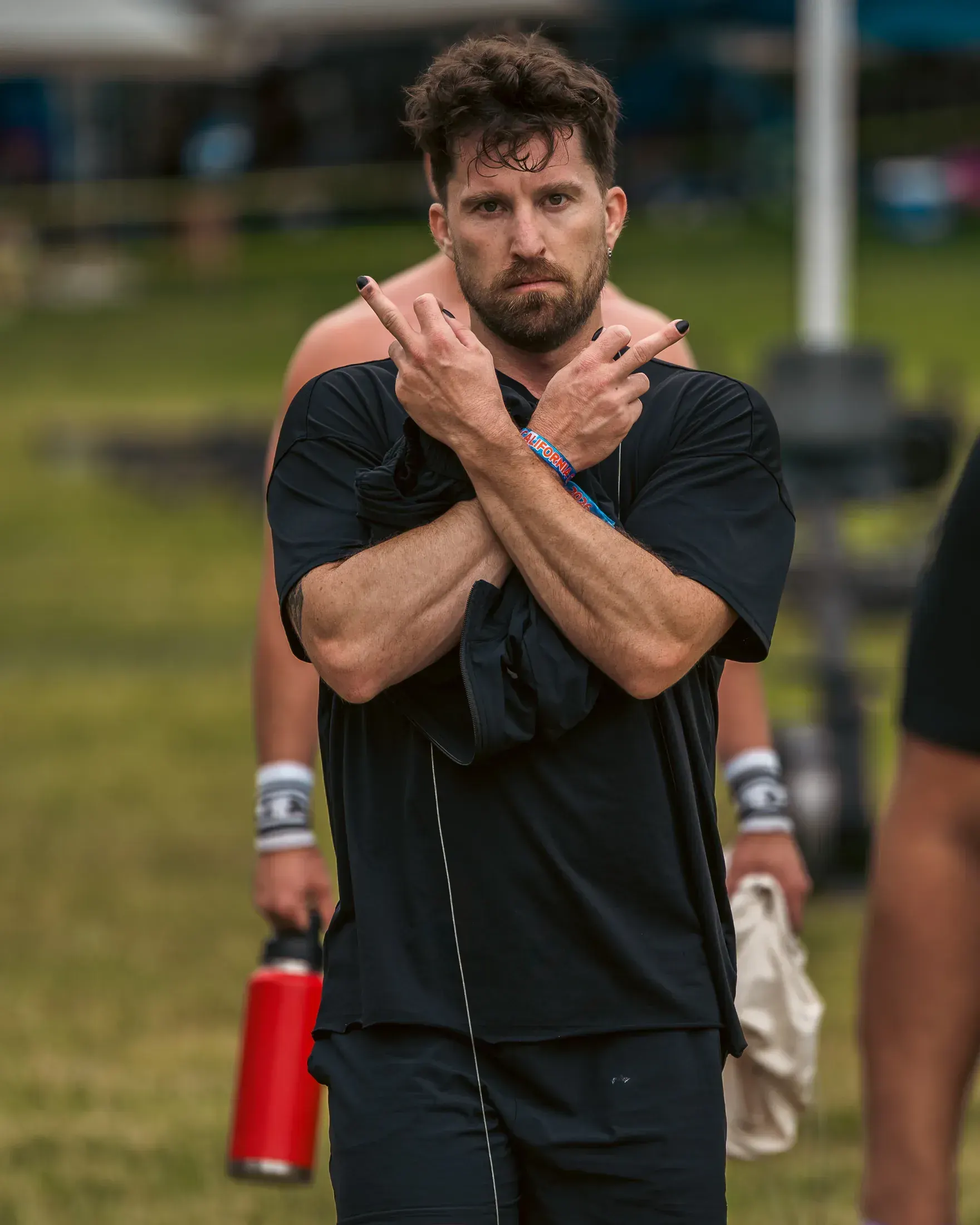 Athlete crossing his arms on the field between events