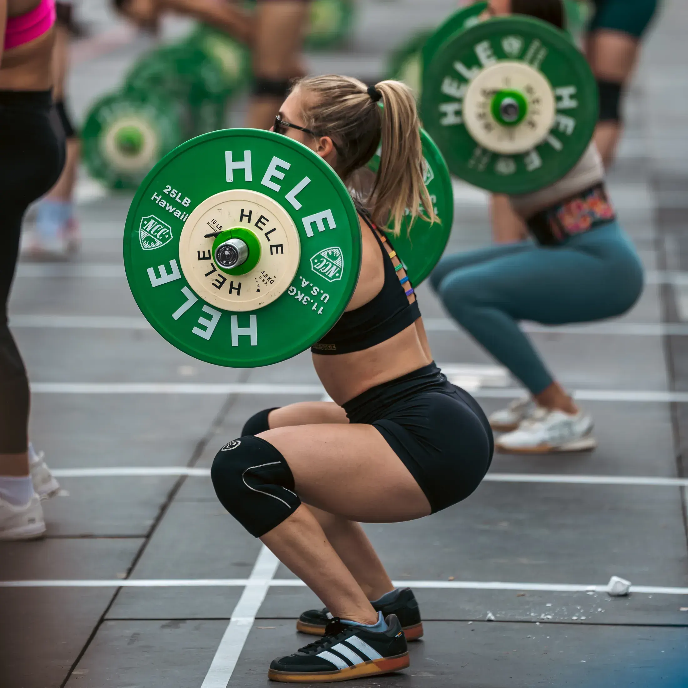 Athlete in the bottom of a front squat with green plates