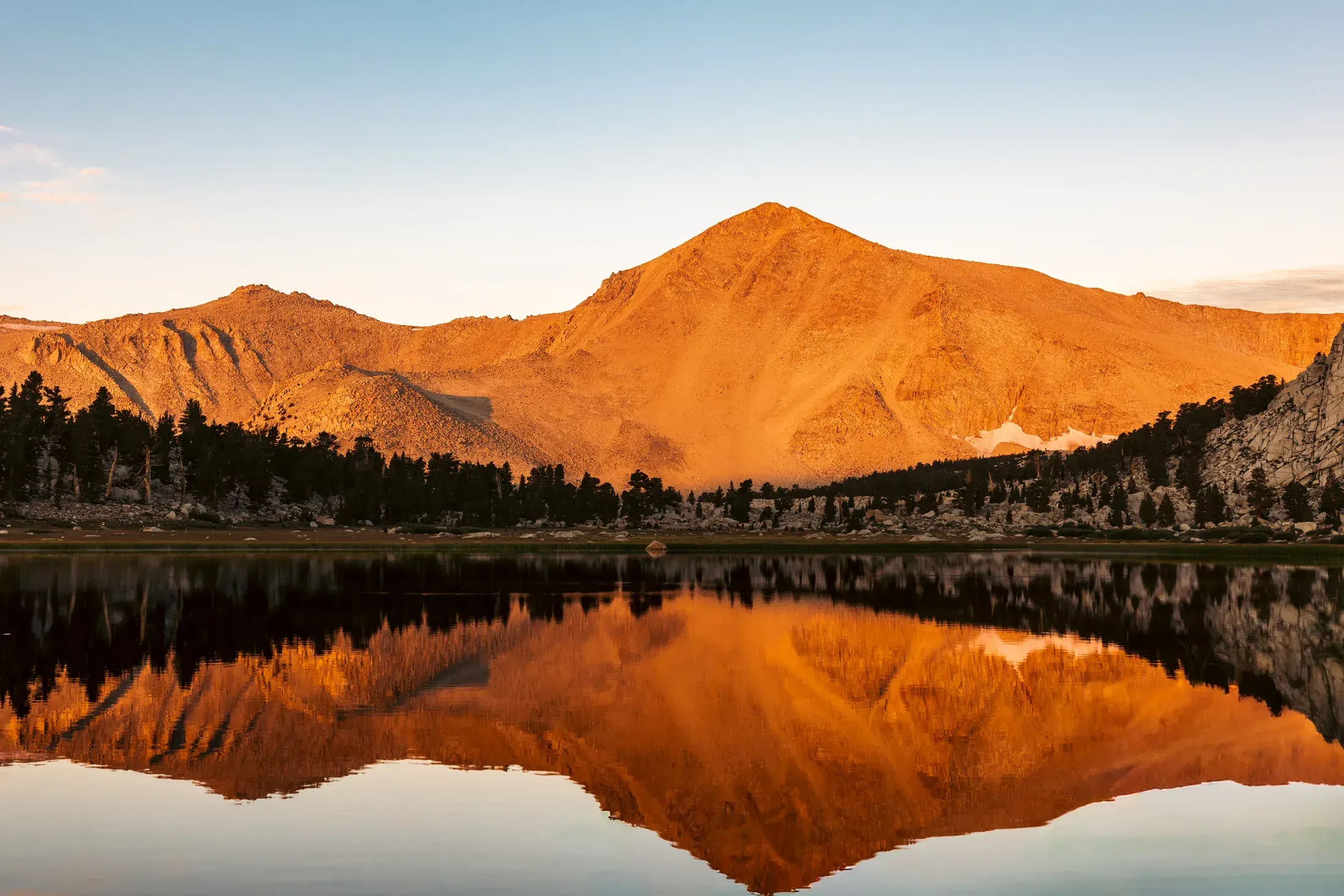 Mountain glowing orange over a still lake at sunset