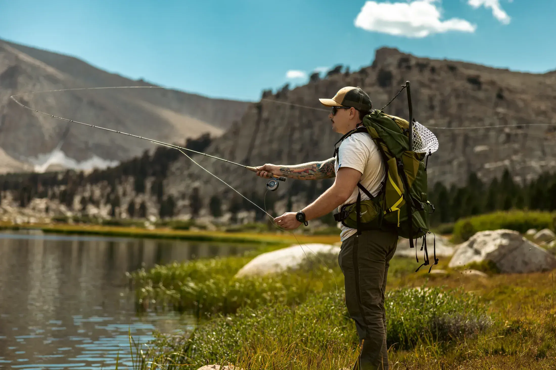 Fly fisherman casting on a Sierra lake