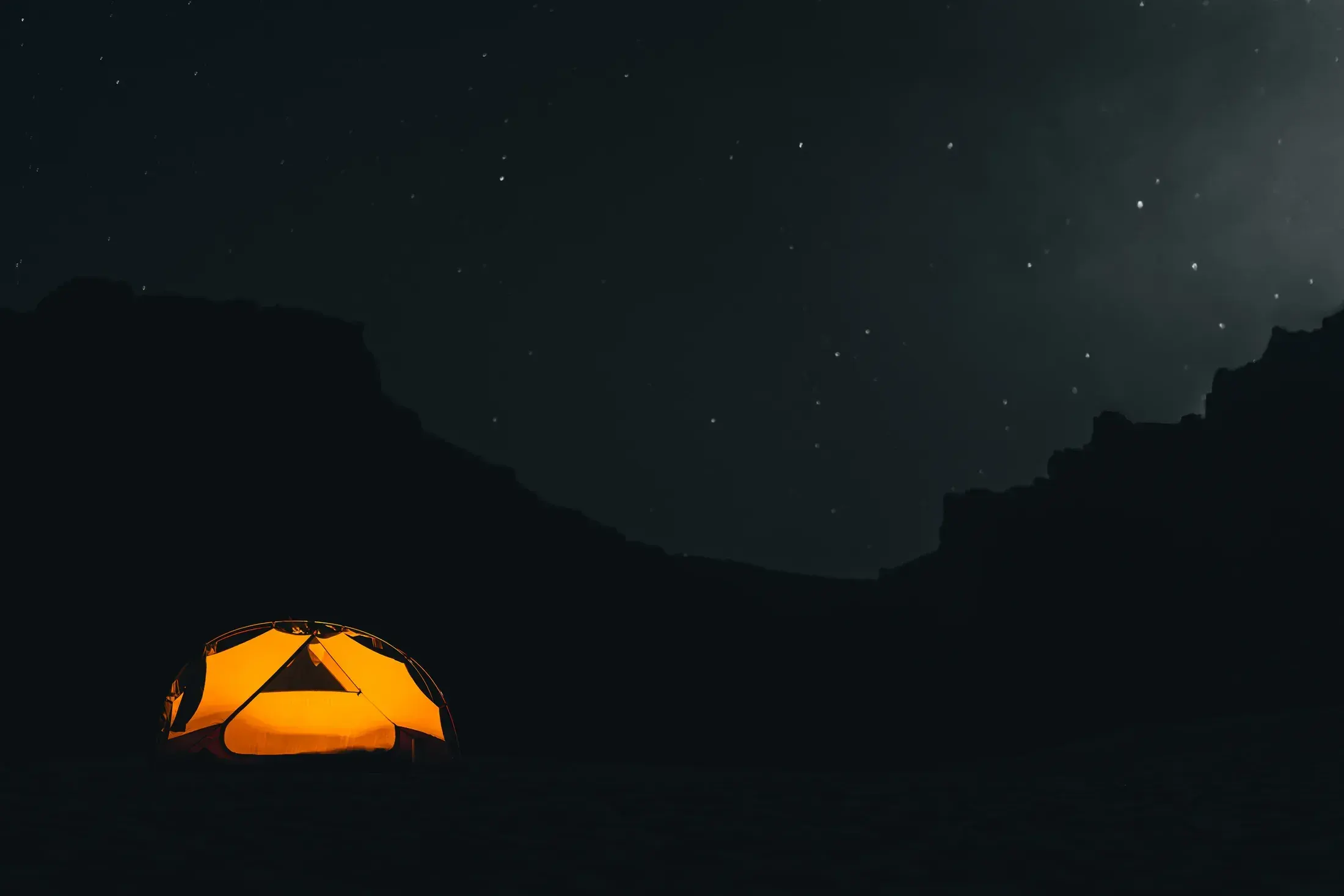 Glowing tent under a starry sky
