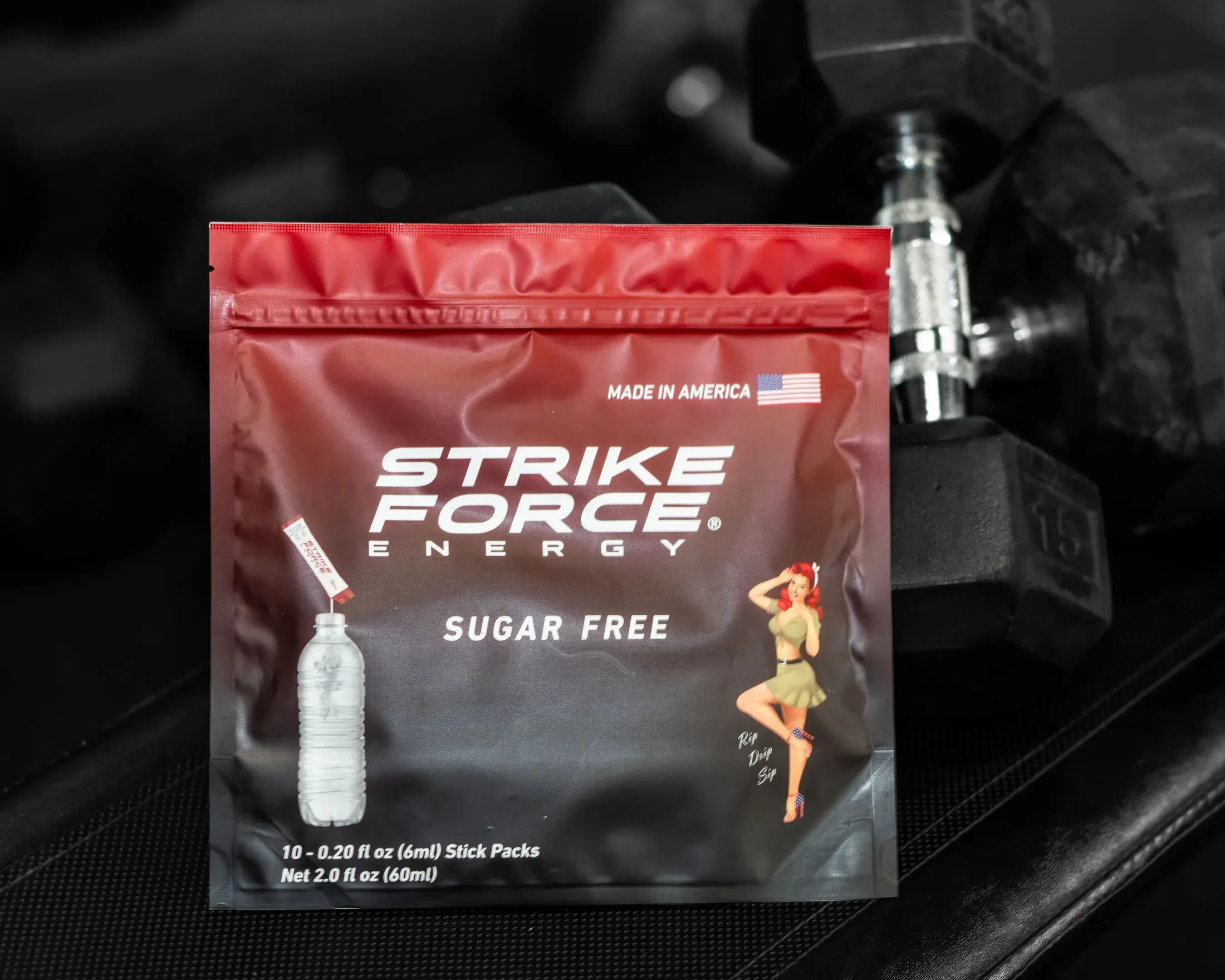 Strike Force Energy sugar free packet in front of dumbbells