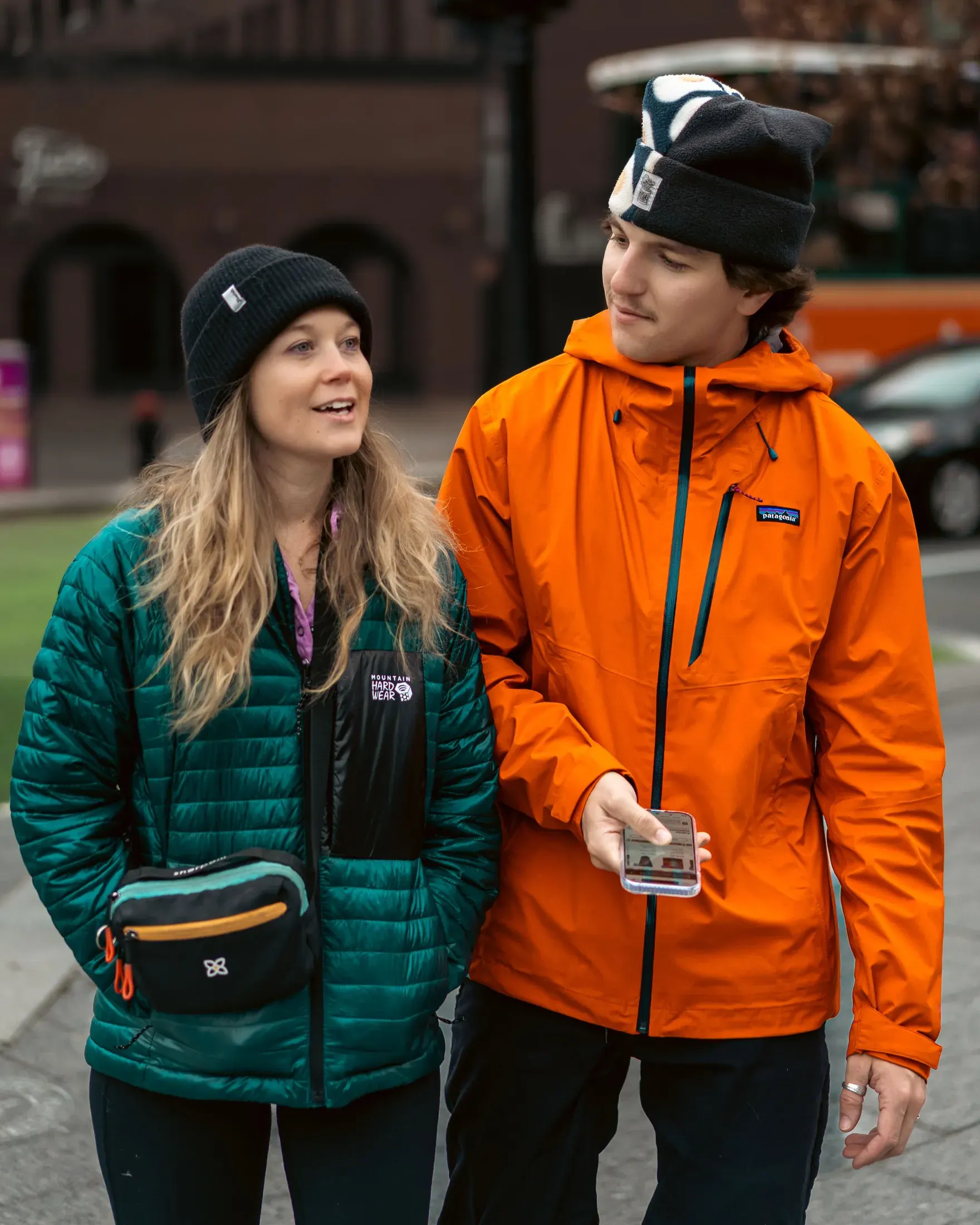 Couple in bright jackets looking at a phone together