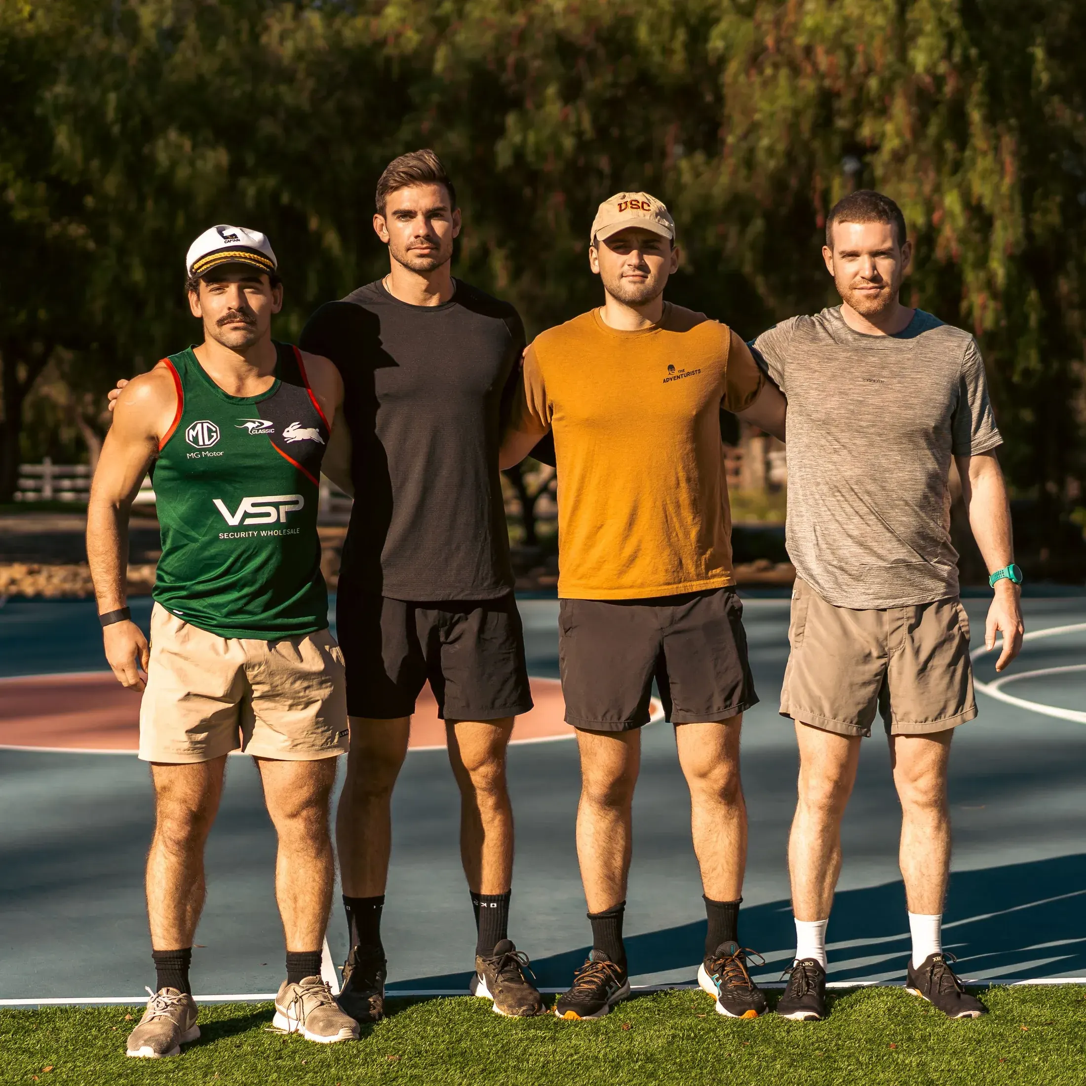 Four friends on a court at an outdoor event
